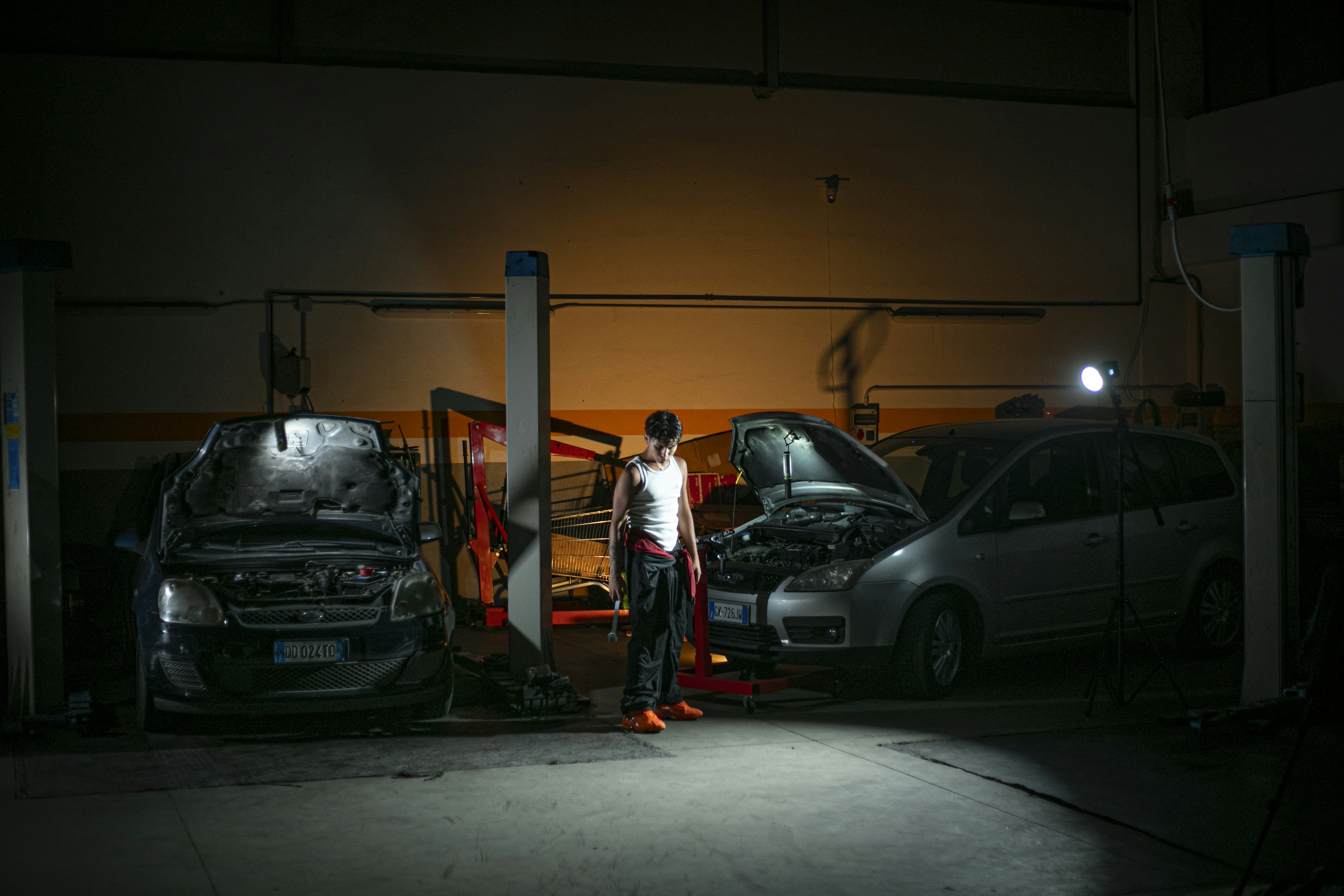 Technician measuring tread depth on an electric vehicle tire in a service bay