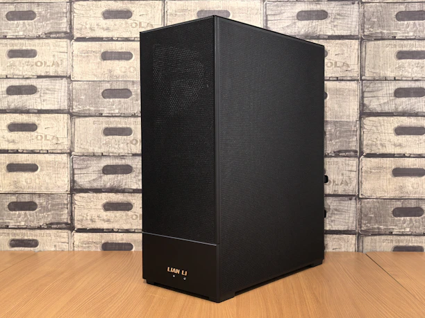 A black computer tower case stands on a wooden surface.