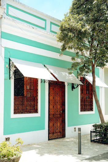 Turquoise building with wooden door and windows
