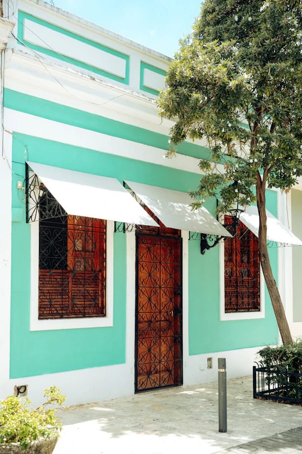 Turquoise building with wooden door and windows