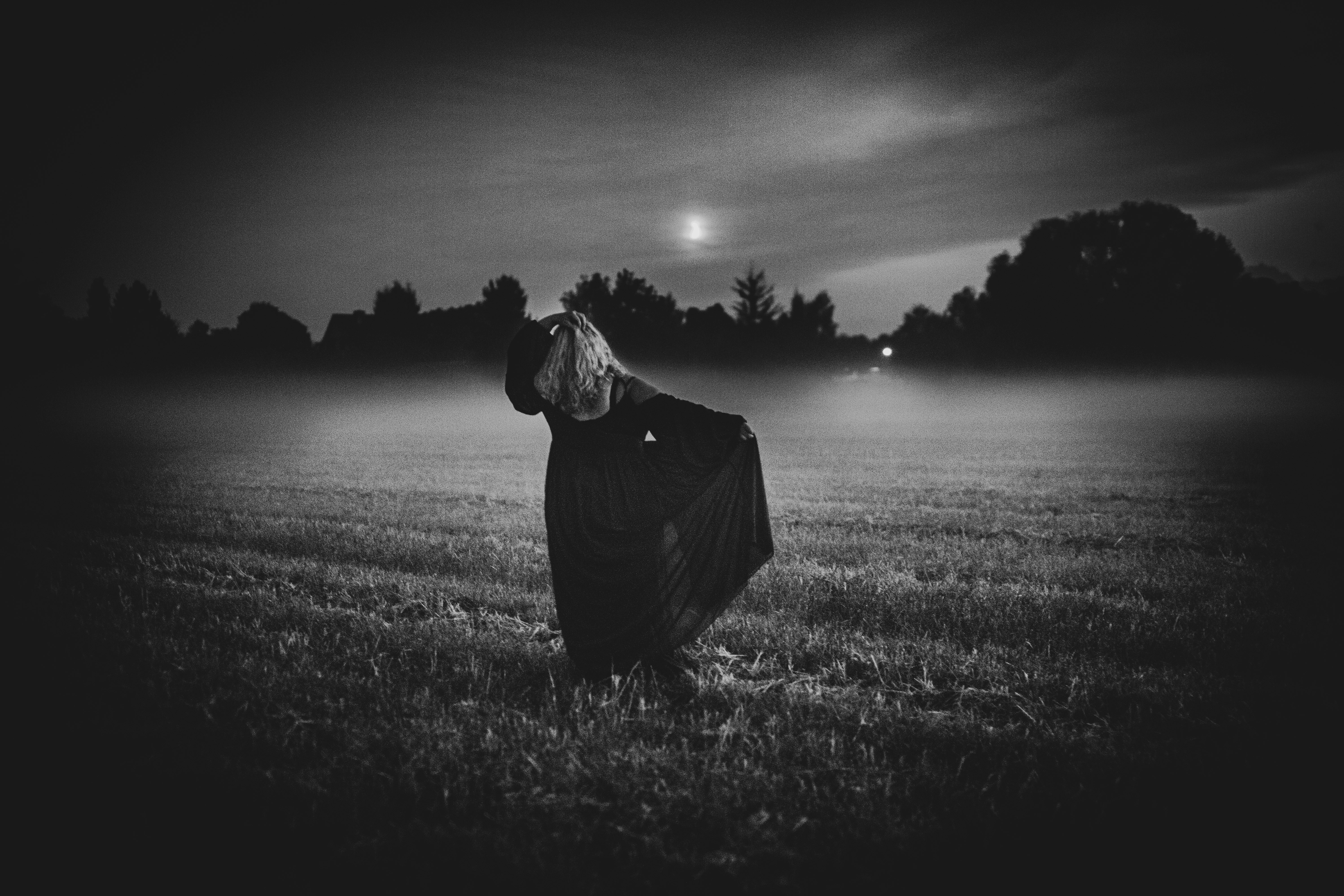 Scarecrow in a misty field at night