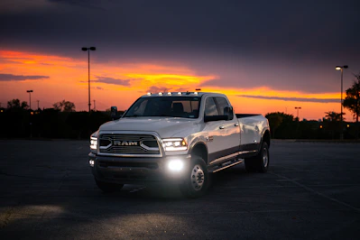 White pickup truck parked at dusk with sunset sky