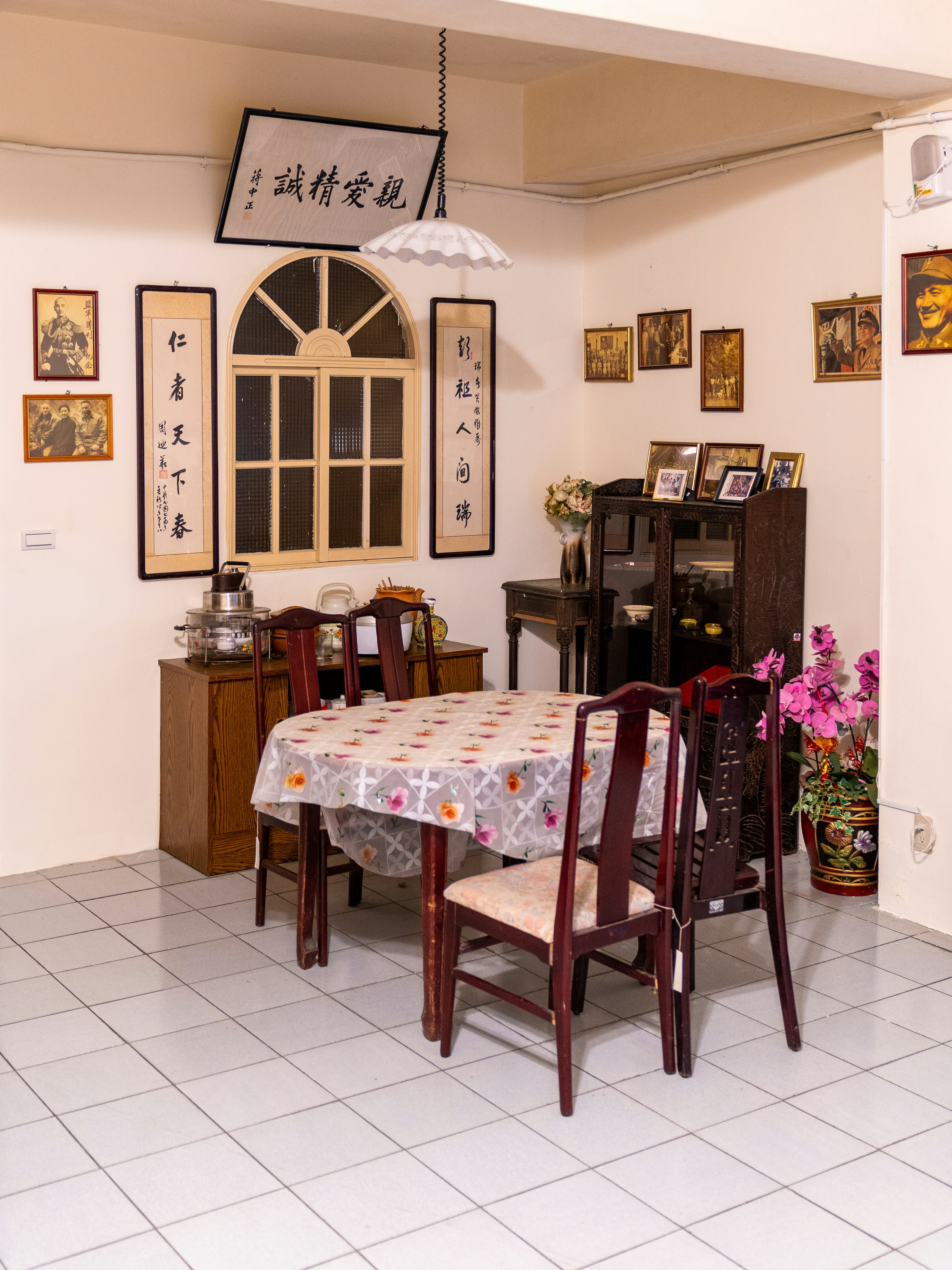 Esszimmer mit Tisch, Stühlen und Kunstwerken.