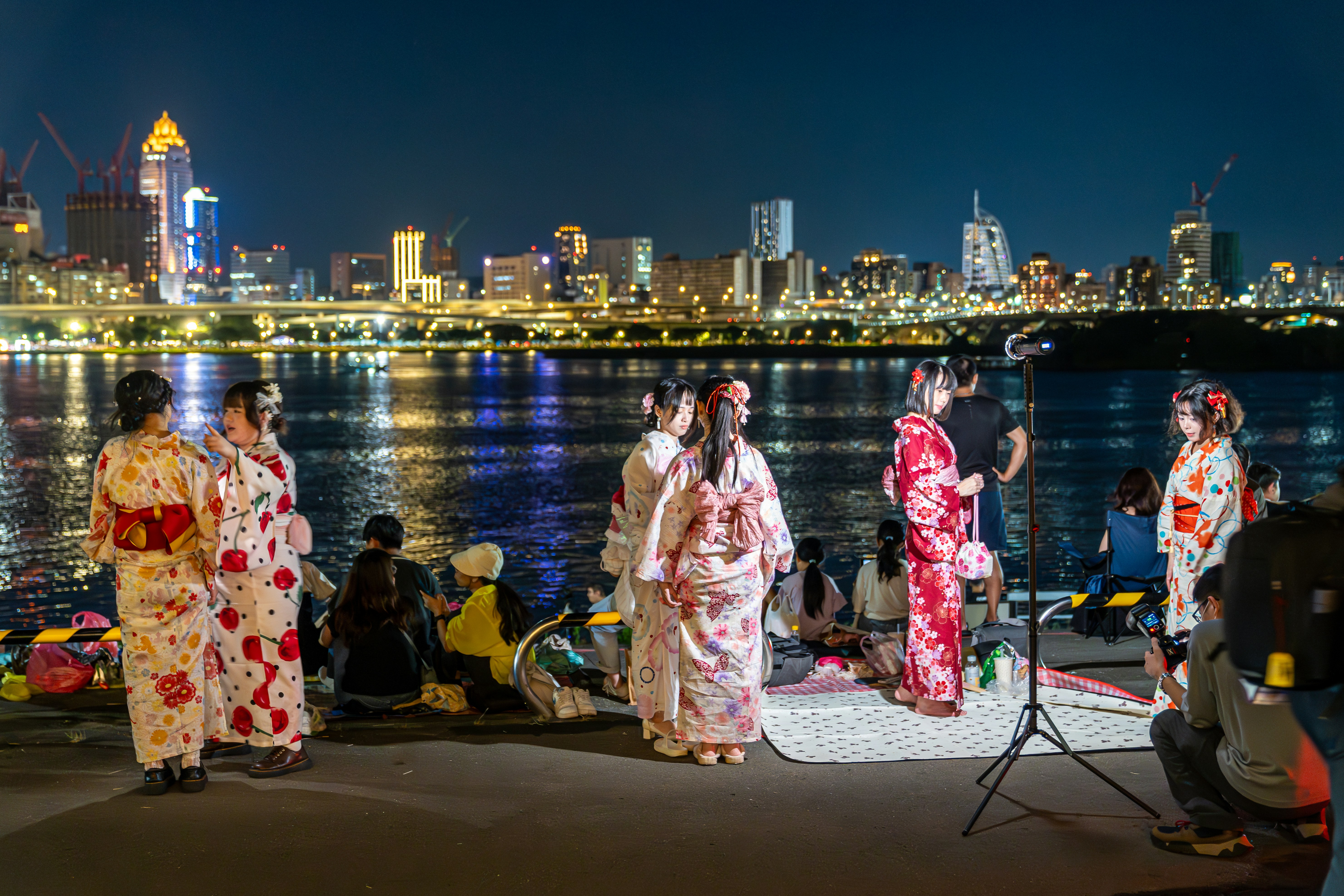 Persone in kimono vicino all'acqua di notte