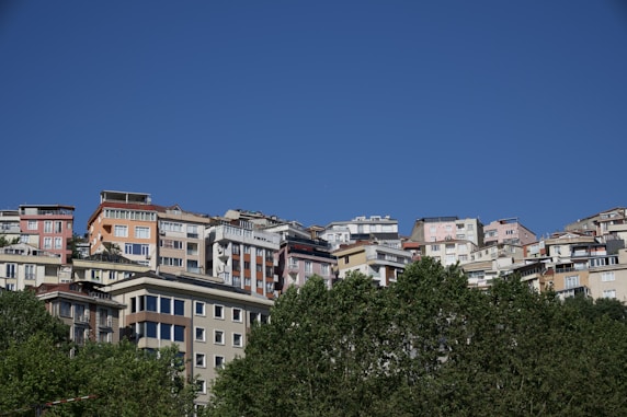 City buildings on a hill under a clear blue sky.