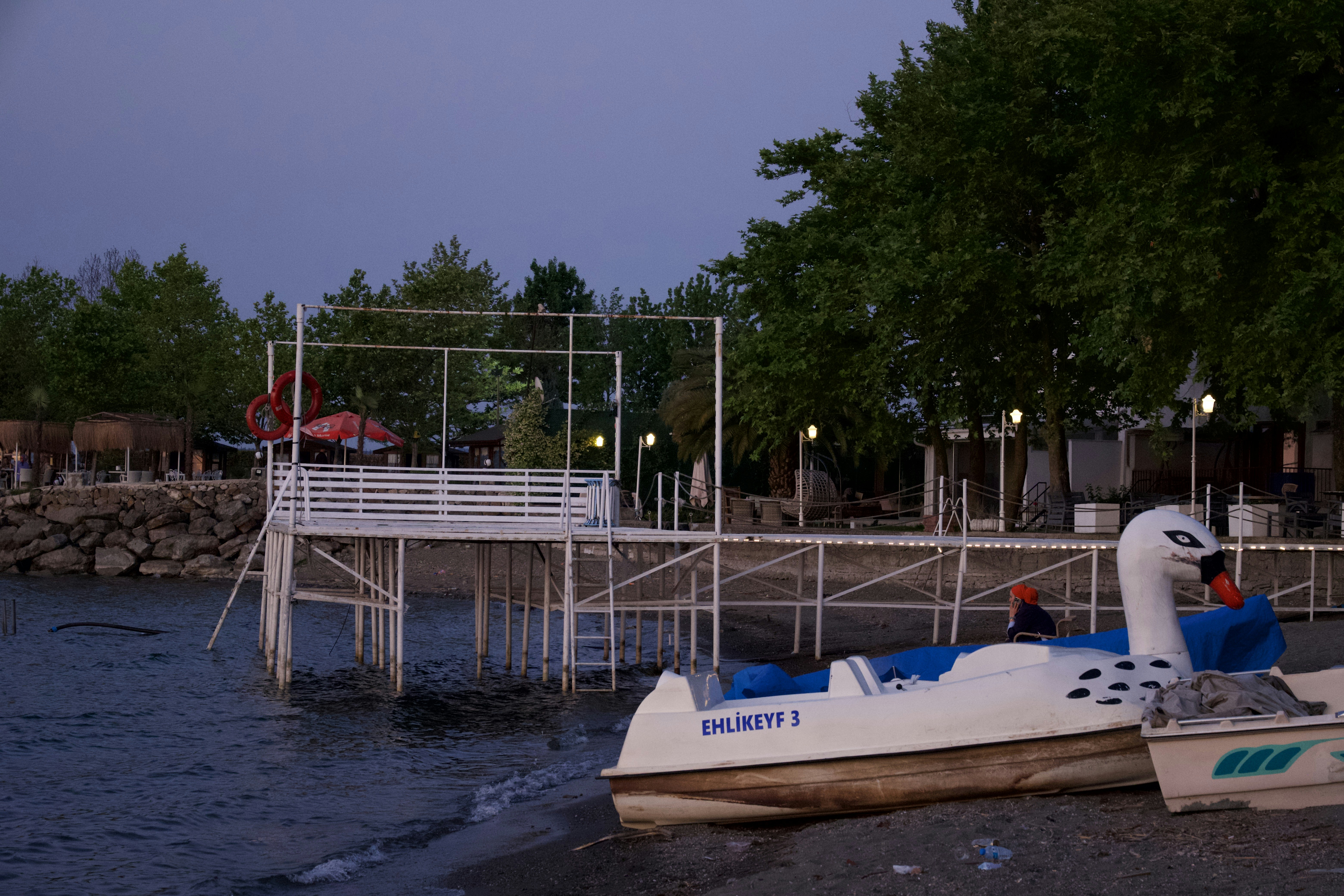 Boats on shore near pier at dusk