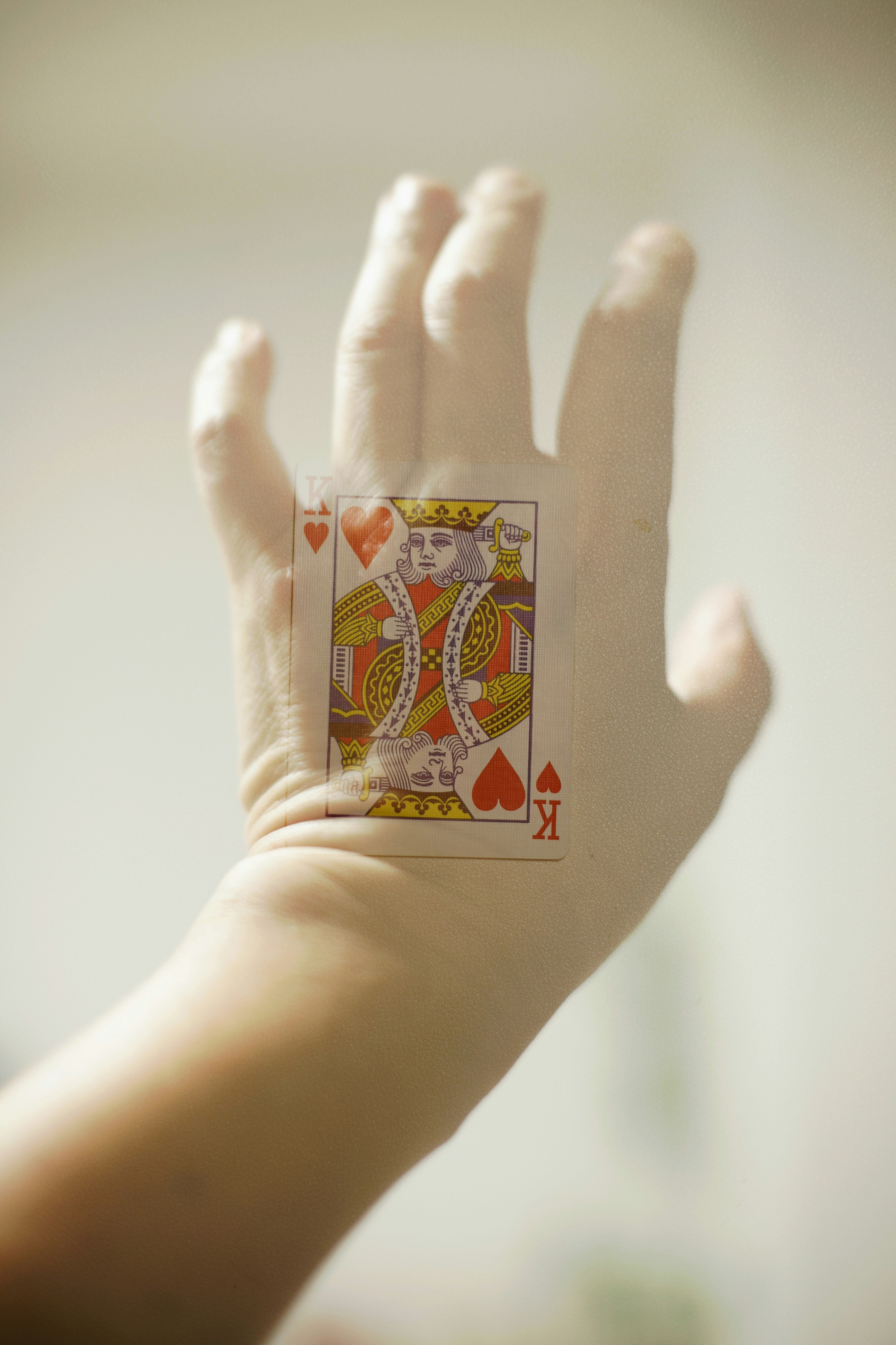 King of hearts card on a gloved hand.