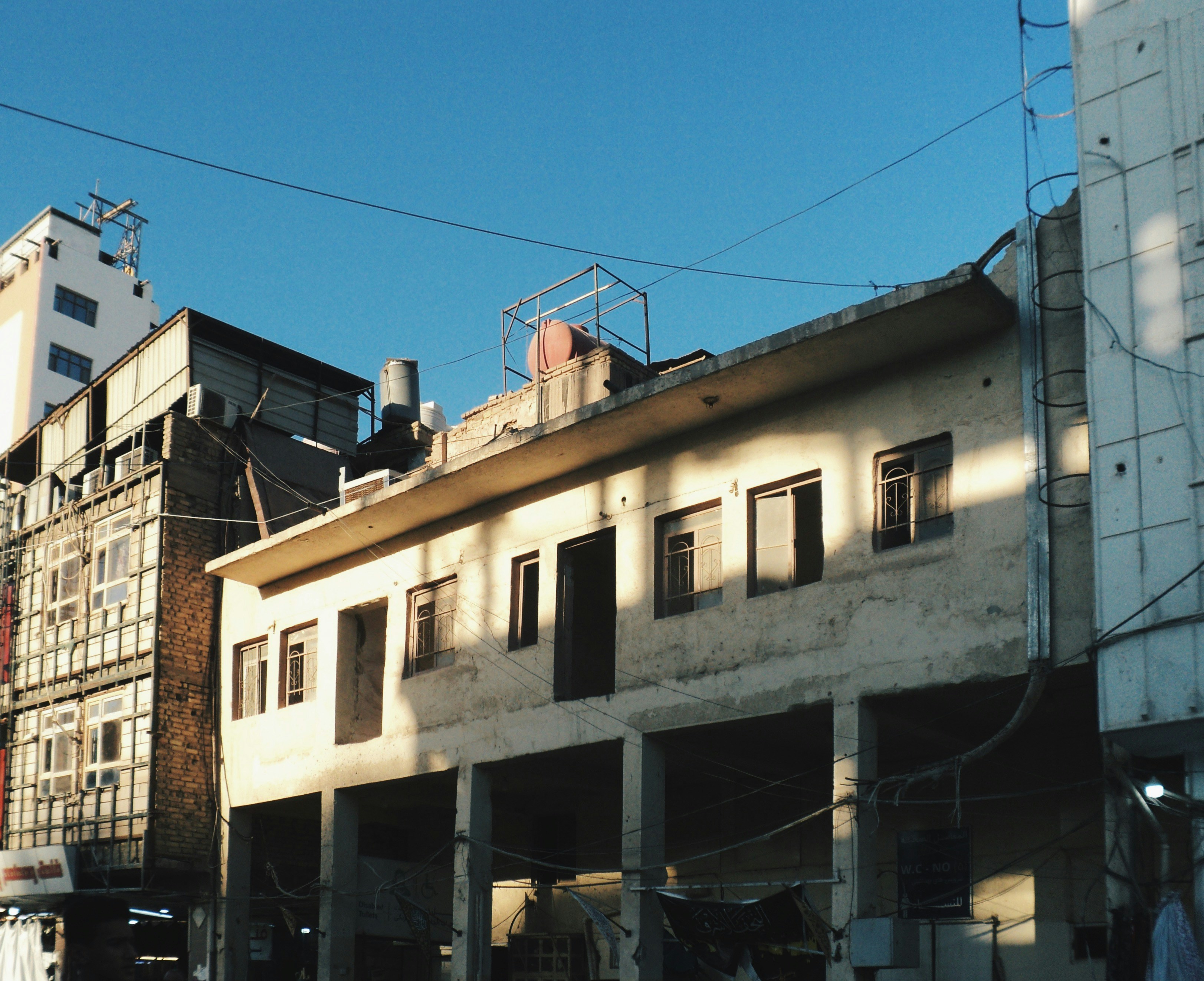 Old building with open windows under blue sky