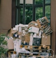 Cardboard boxes and paper waste piled on wooden pallets.