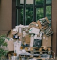 Cardboard boxes and paper waste piled on wooden pallets.