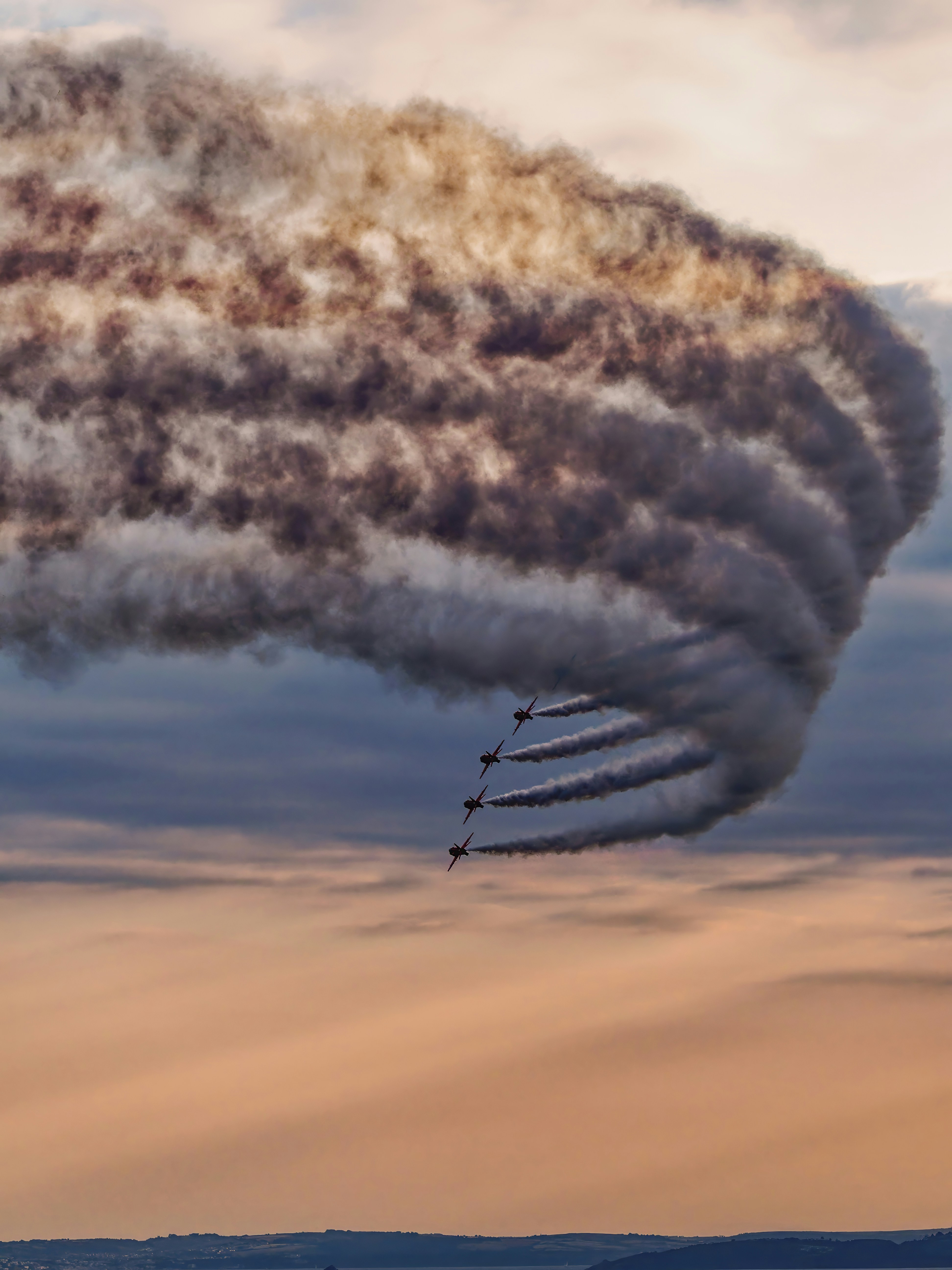 Airplanes create smoke trails in a cloudy sky