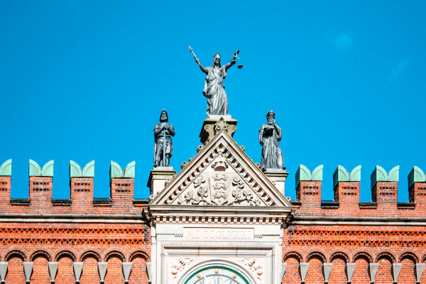Statue of Lady Justice atop a building against a blue sky