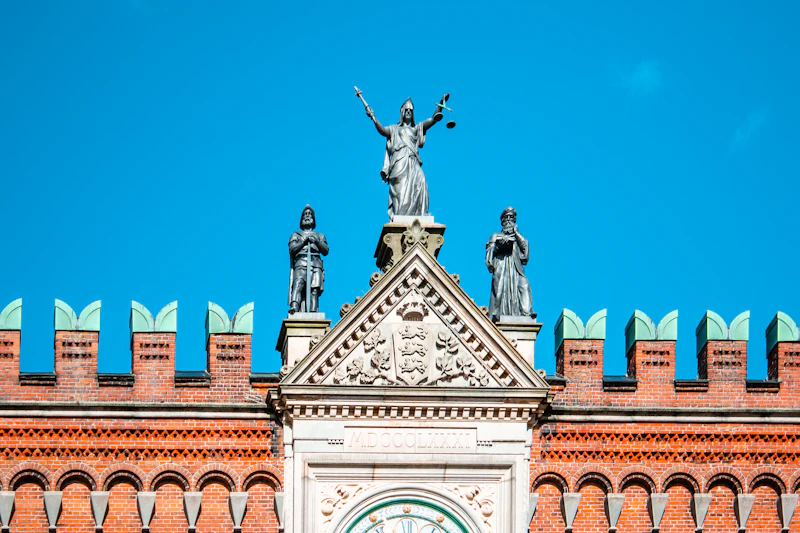Statue of Lady Justice atop a building against a blue sky