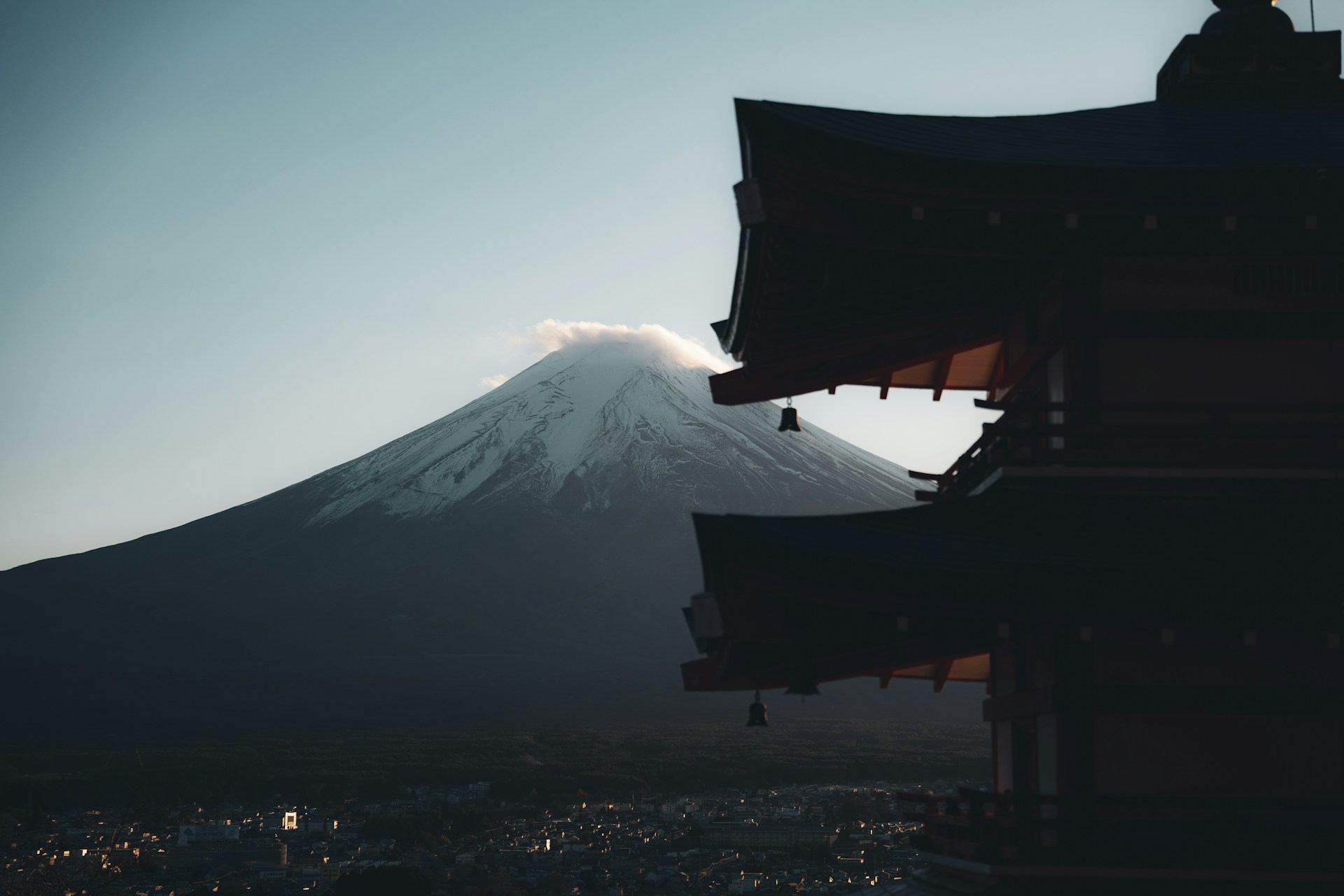 Mount fuji seen behind a traditional japanese temple.