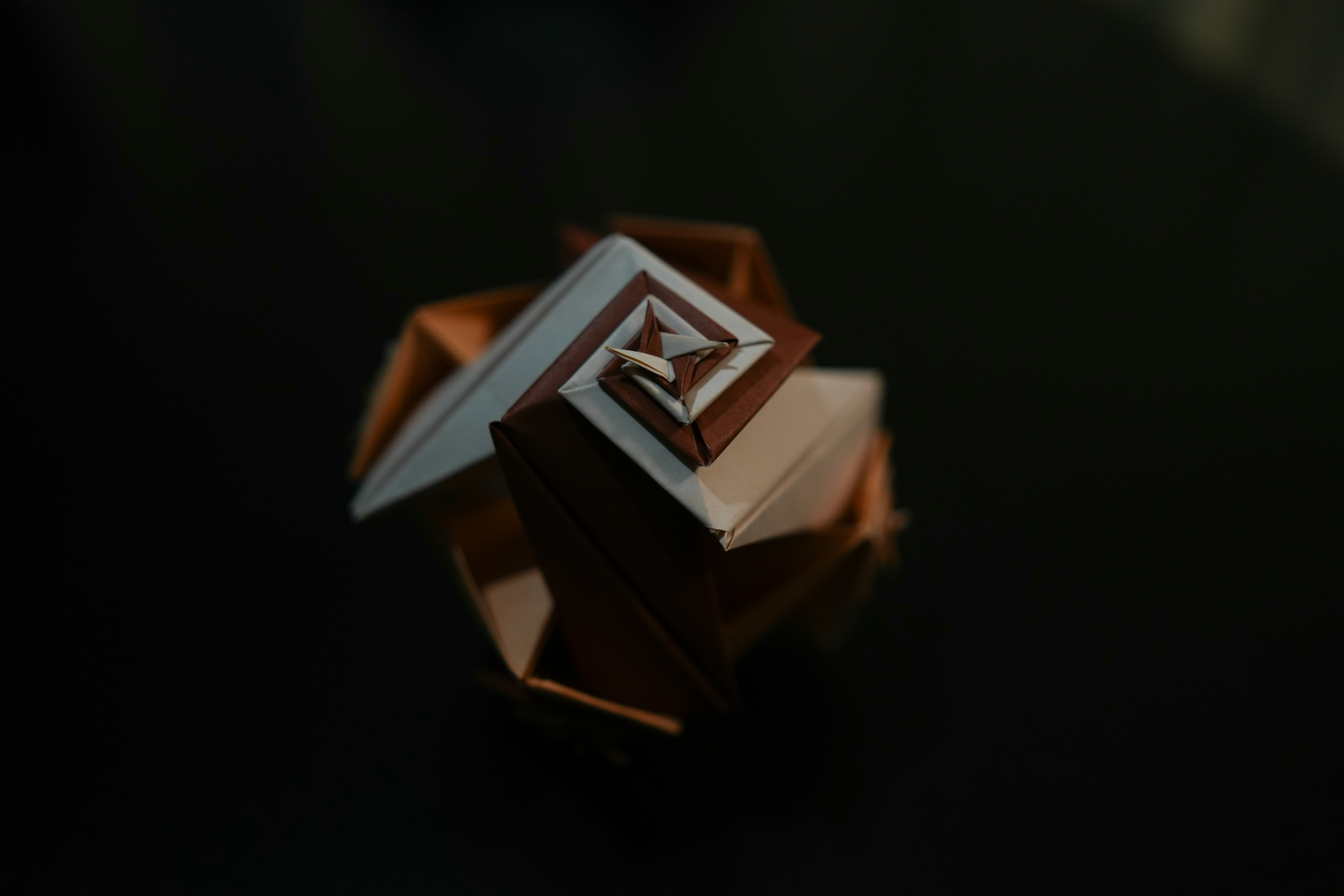 Geometric origami sculpture on dark background