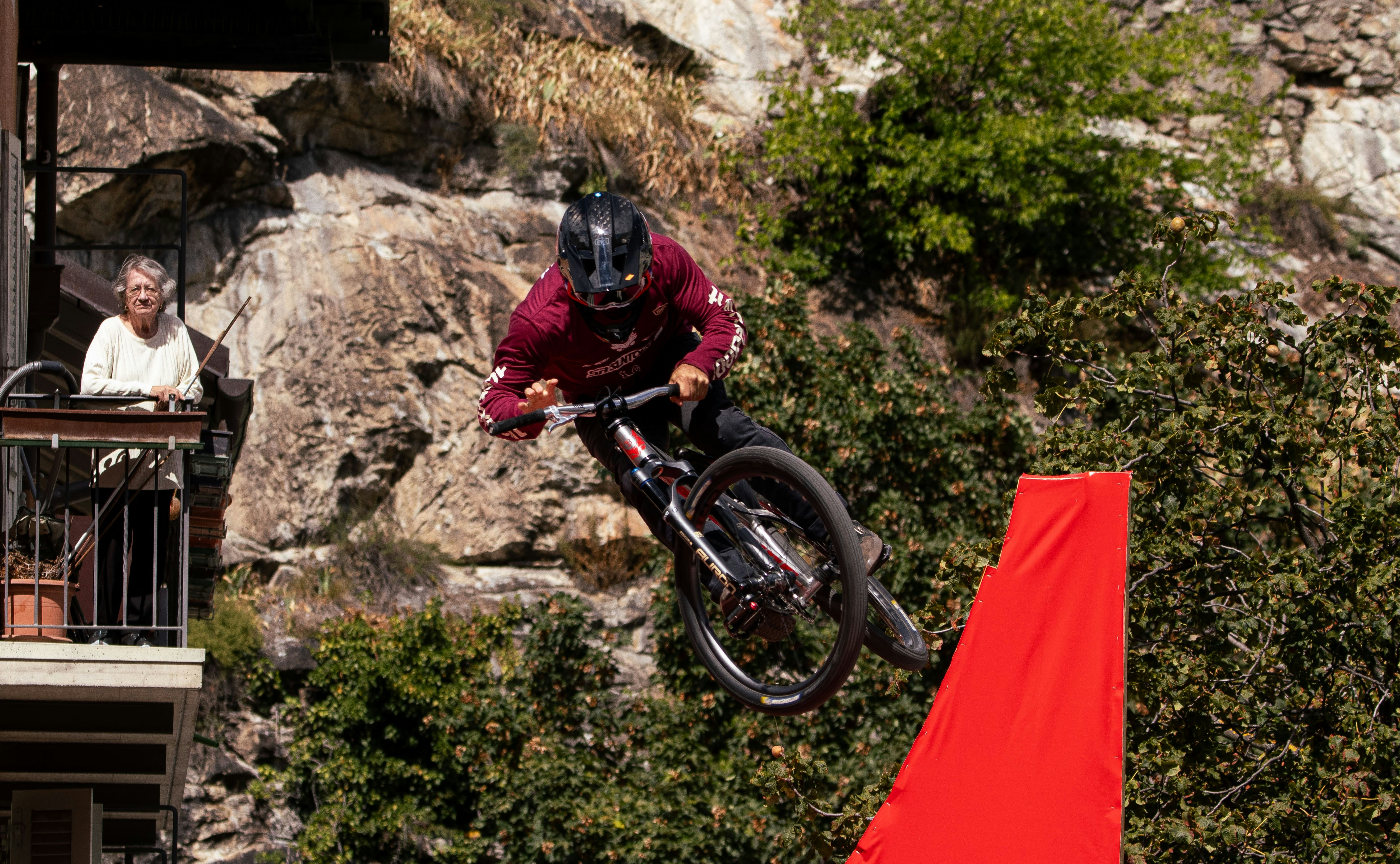 Mountain biker jumps over obstacle near red obstacle