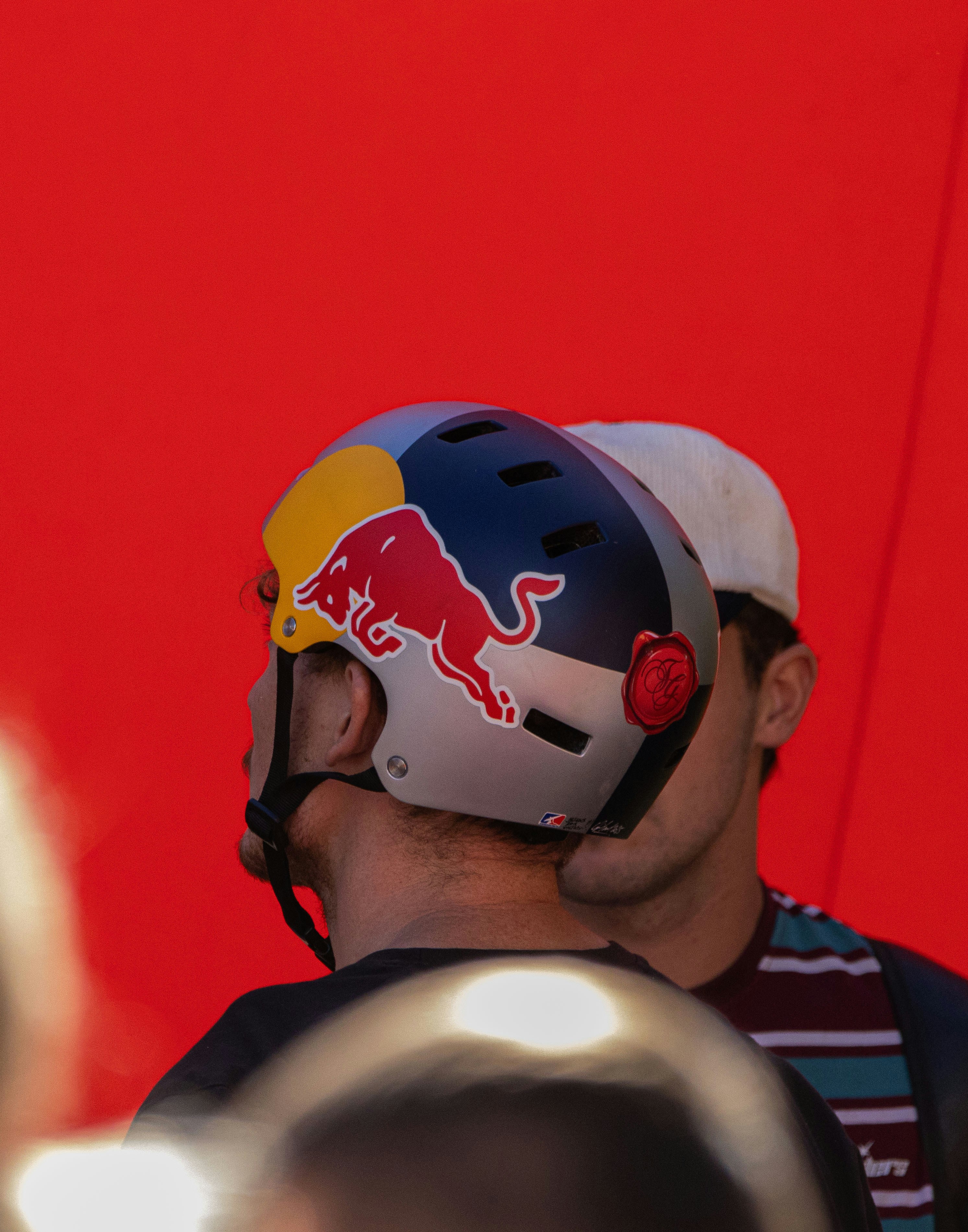 Man wearing a red bull helmet against red background