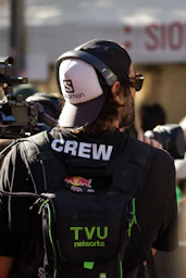 A cameraman wearing a hat and headphones with headphones