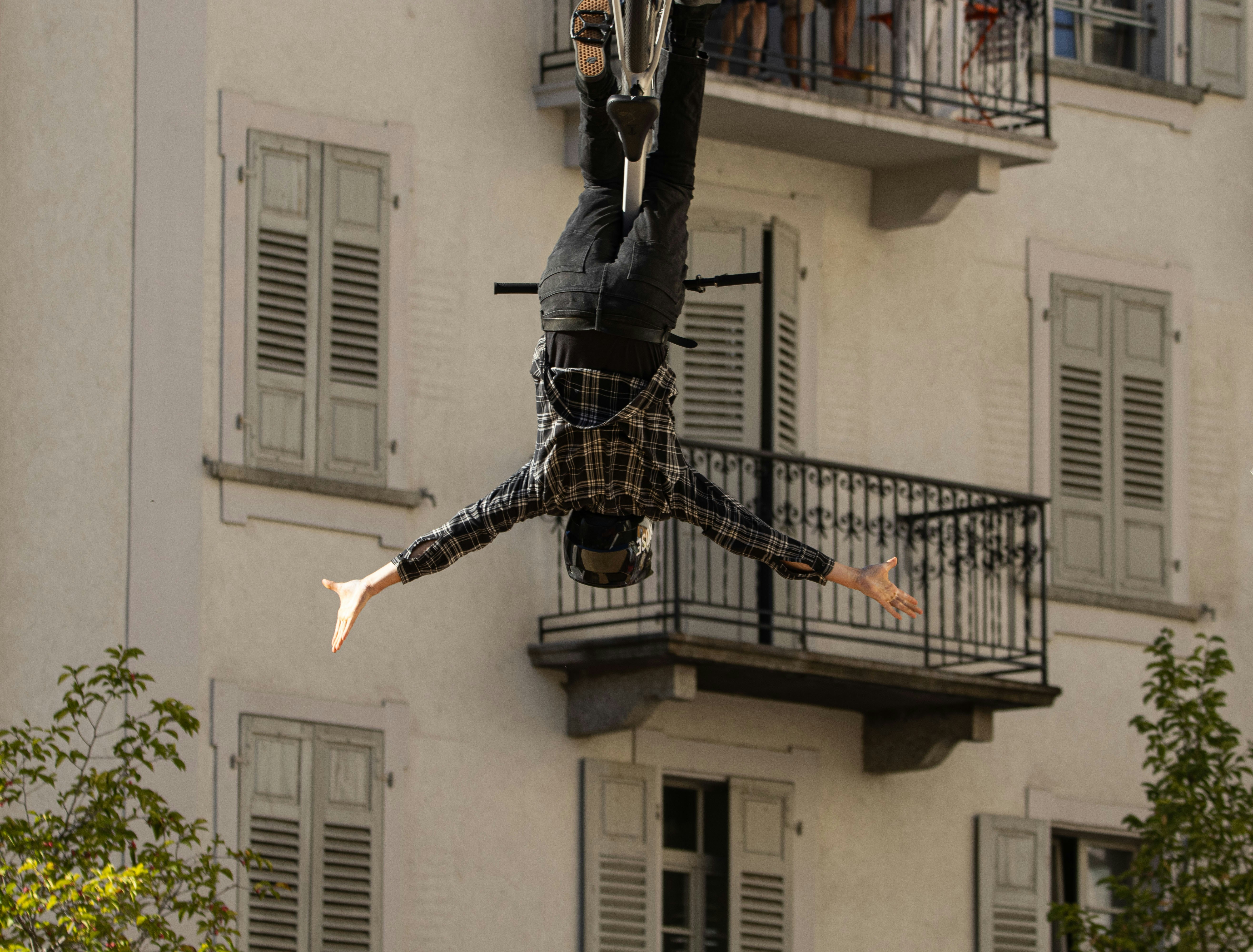 Man on bicycle performs stunt on building