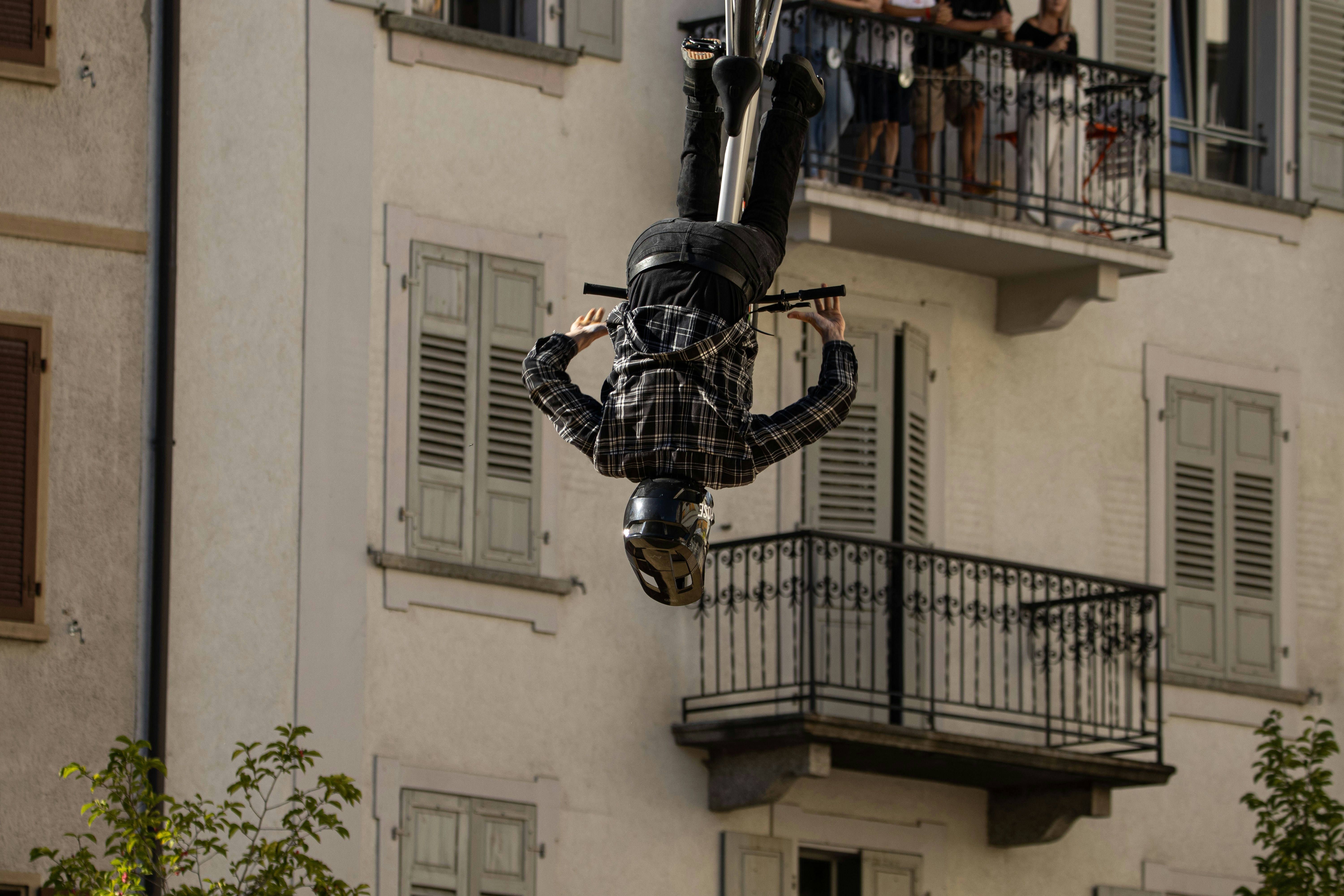 Motorcyclist performs a backflip in front of a building