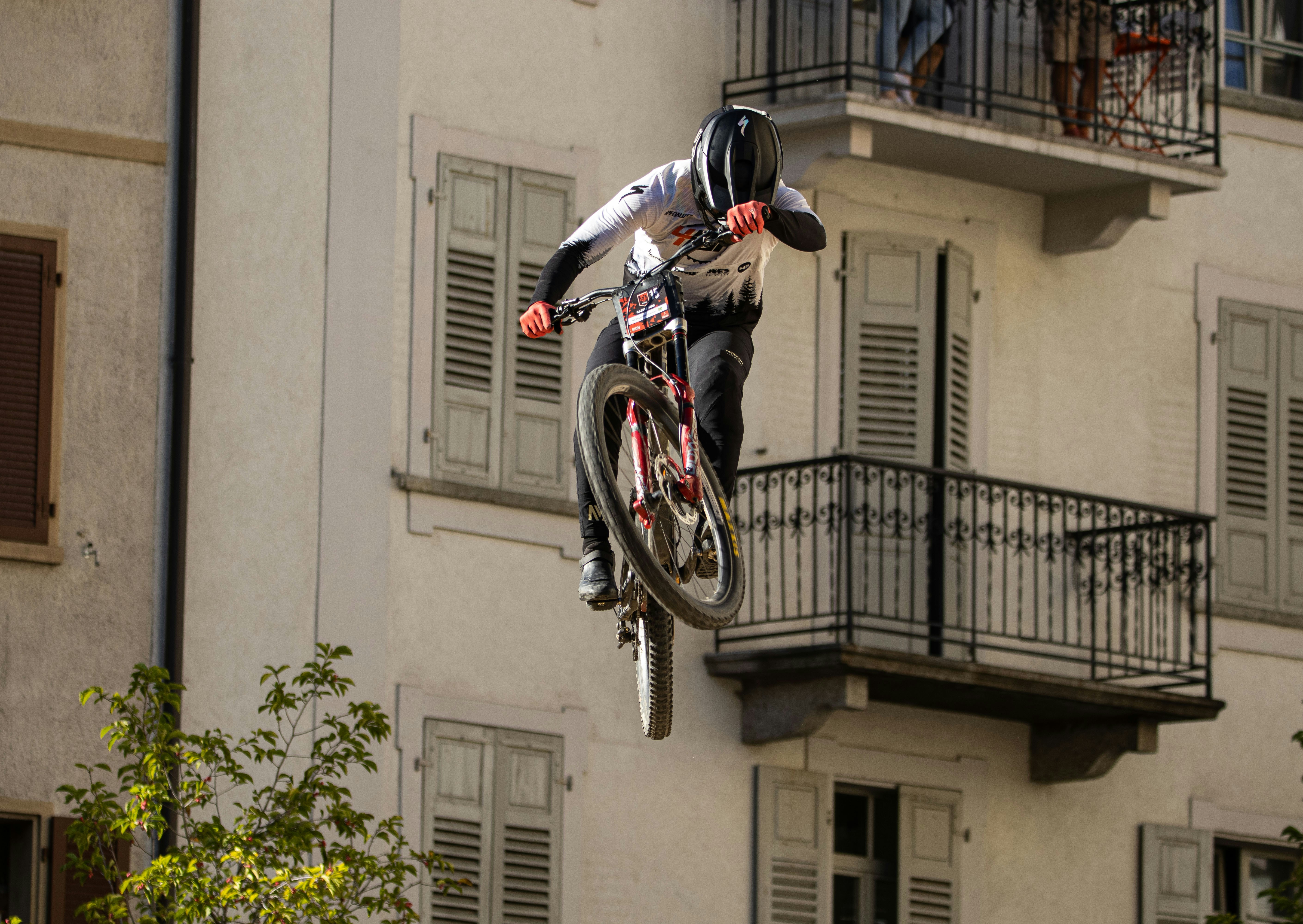 Man on bicycle jumps off building balcony