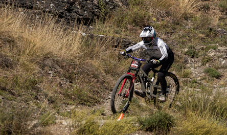 Mountain biker descending a grassy slope