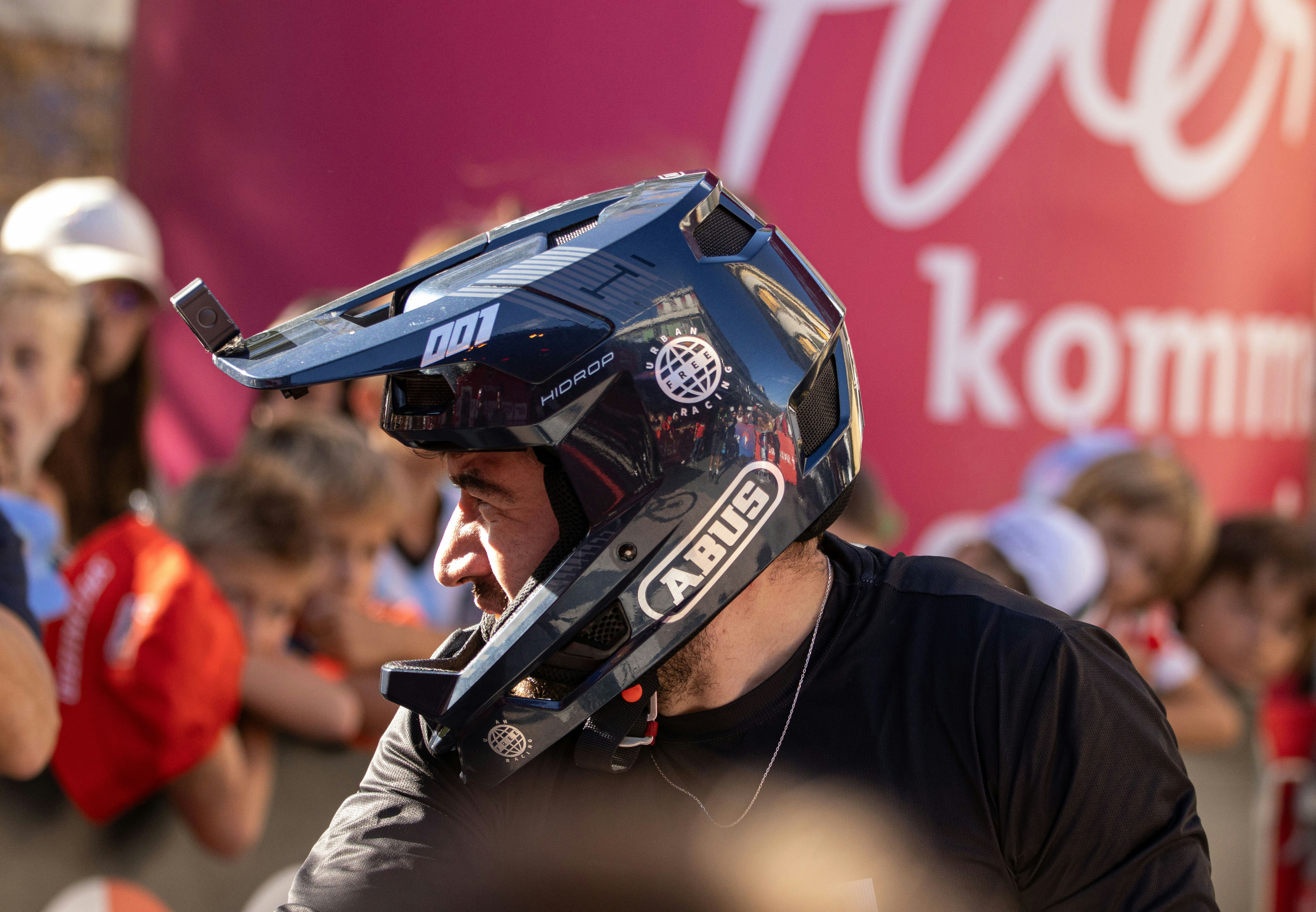 Man wearing a full-face helmet at an event.