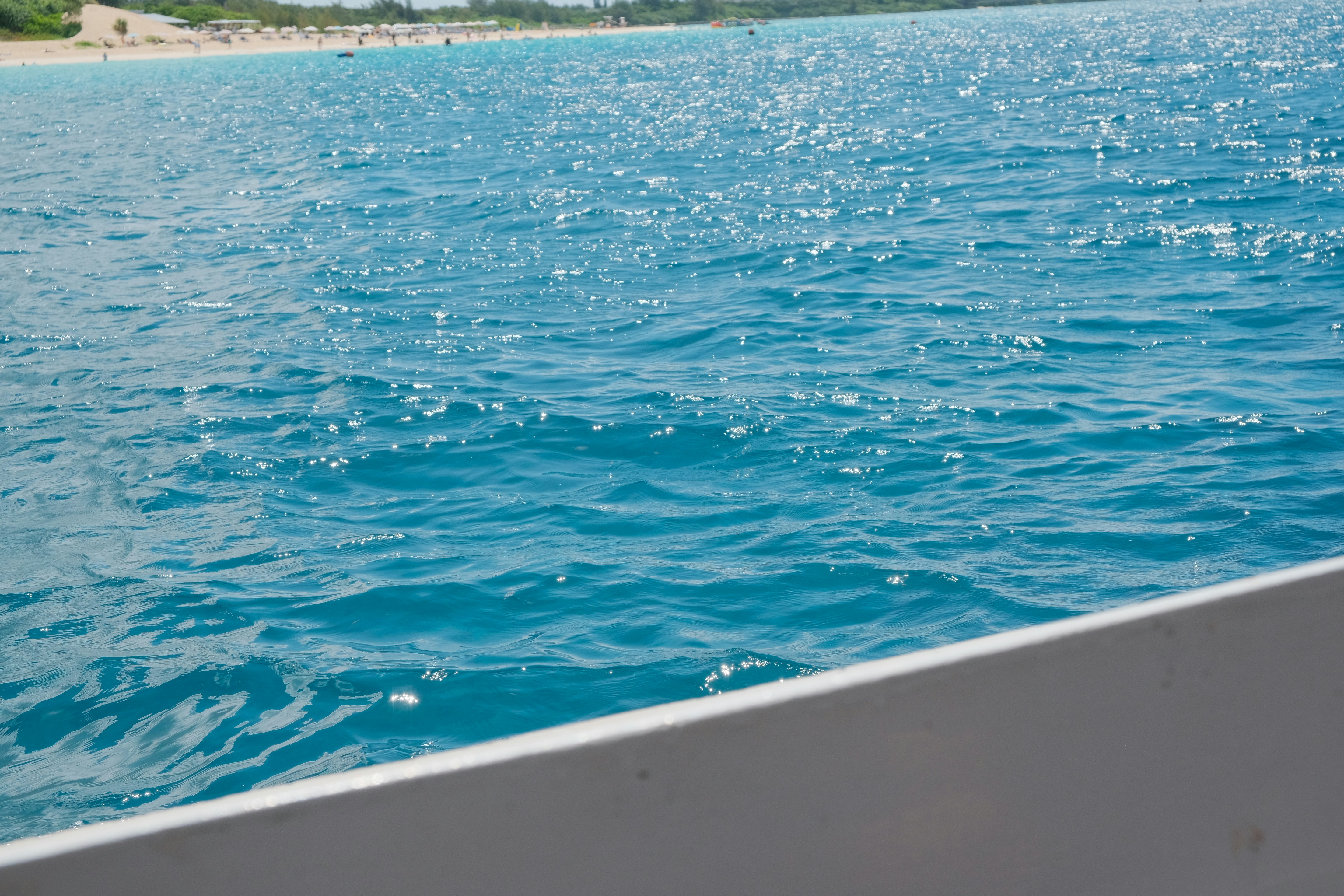 Sparkling turquoise ocean water with a distant shore.