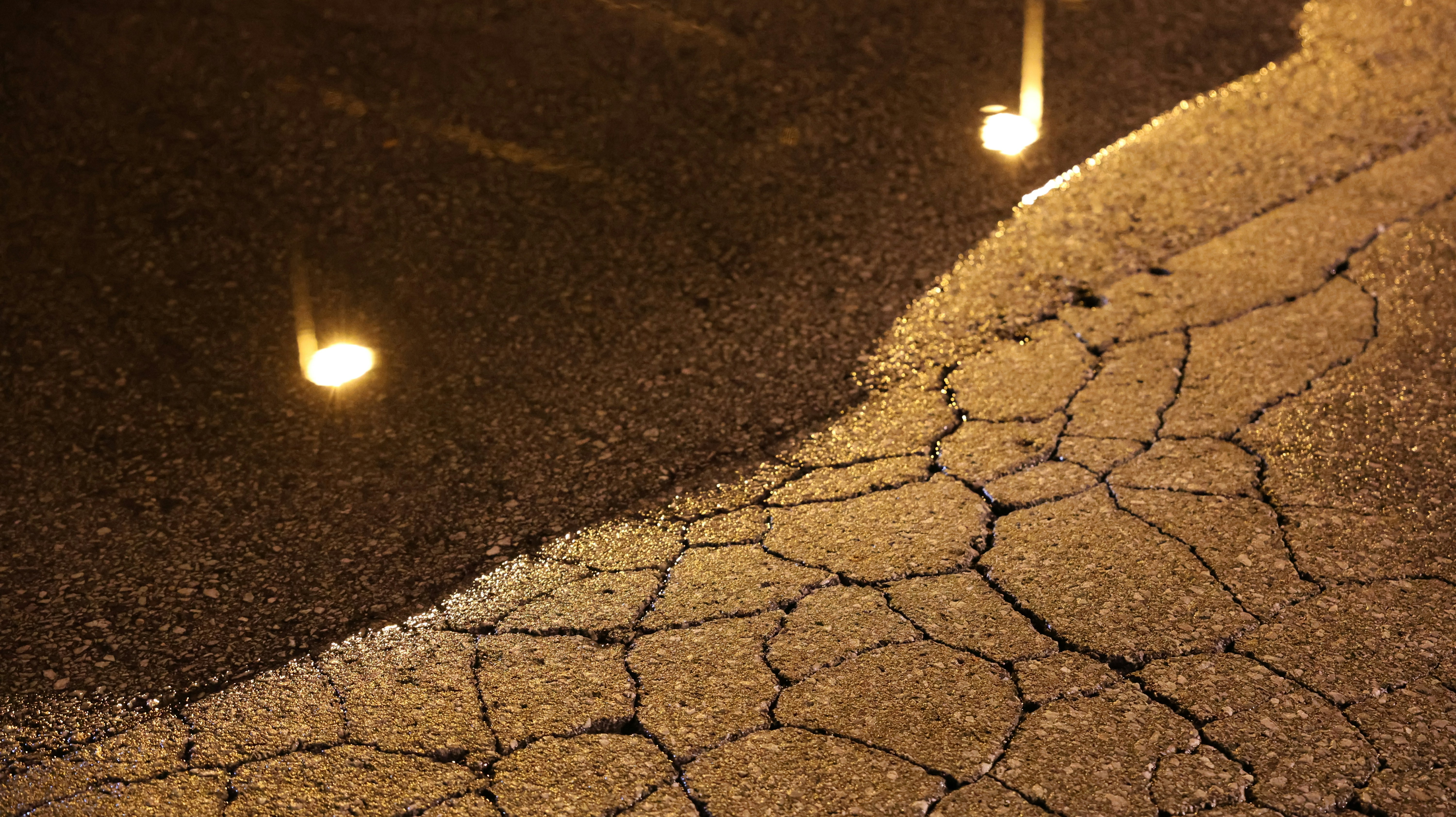 collage of common parking lot hazards: a pothole, an oil spill, a broken curb, and a poorly lit area at night. - parking lot fall