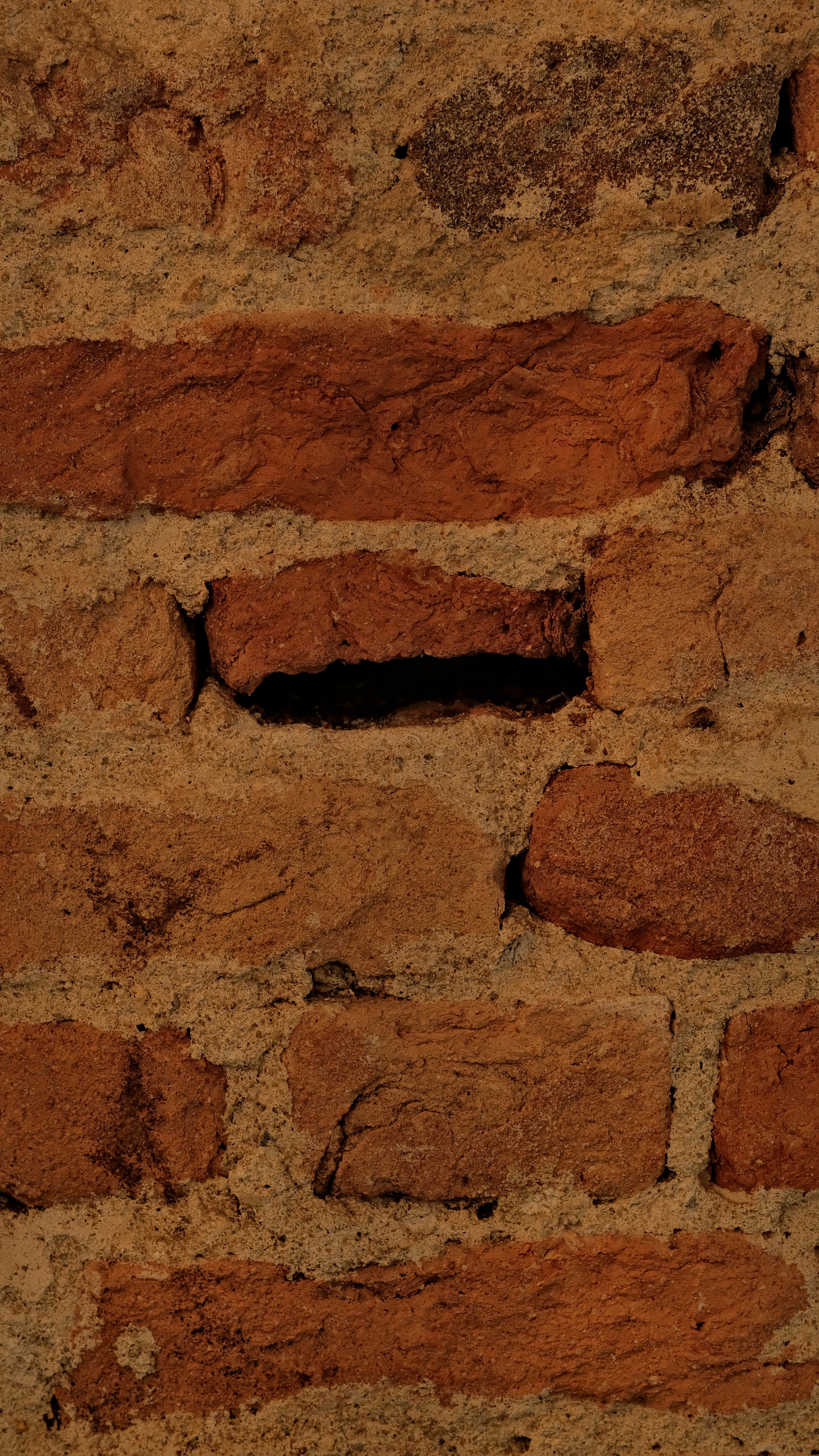 Close-up of a weathered red brick wall
