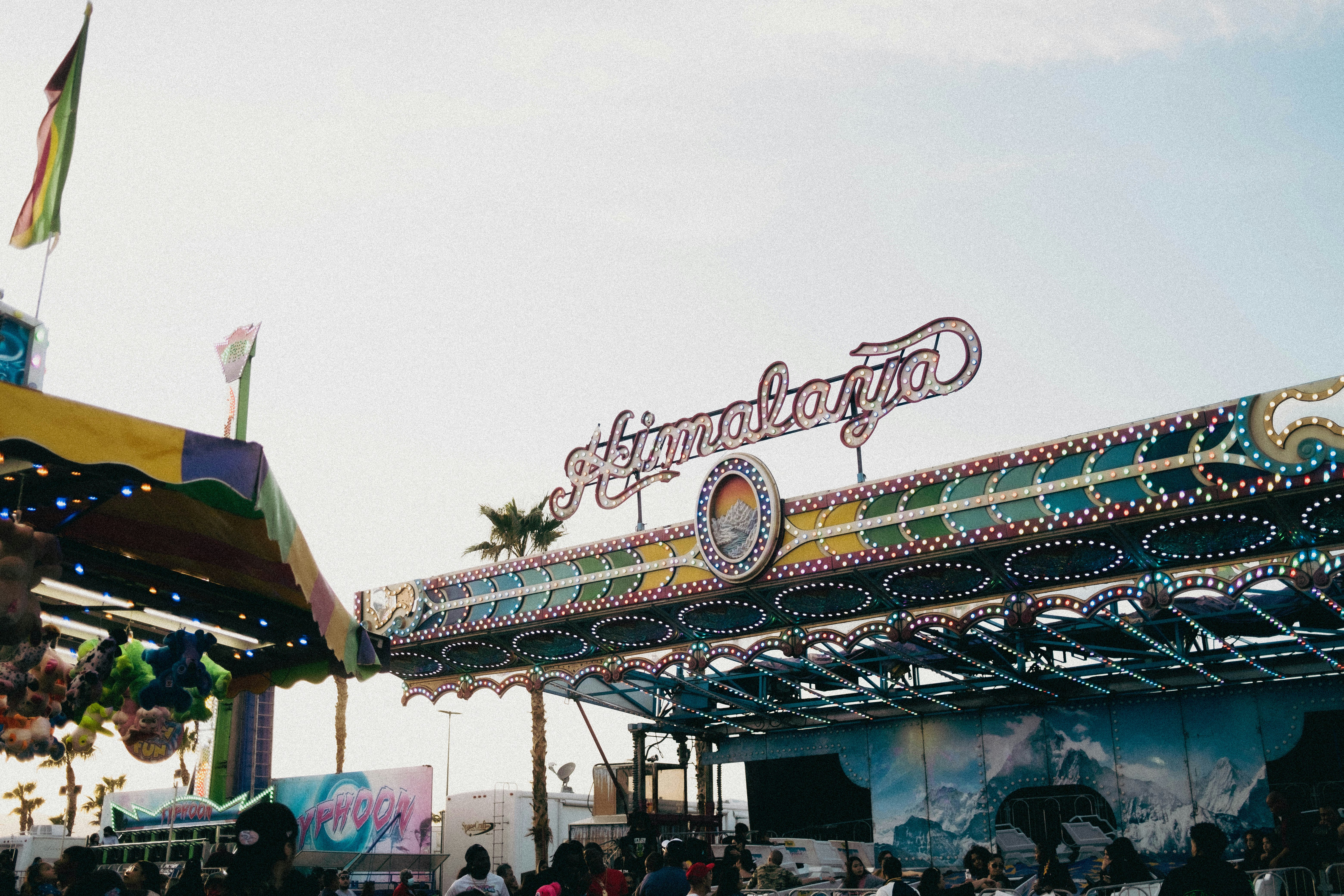 Amusement park ride with colorful lights and sign.