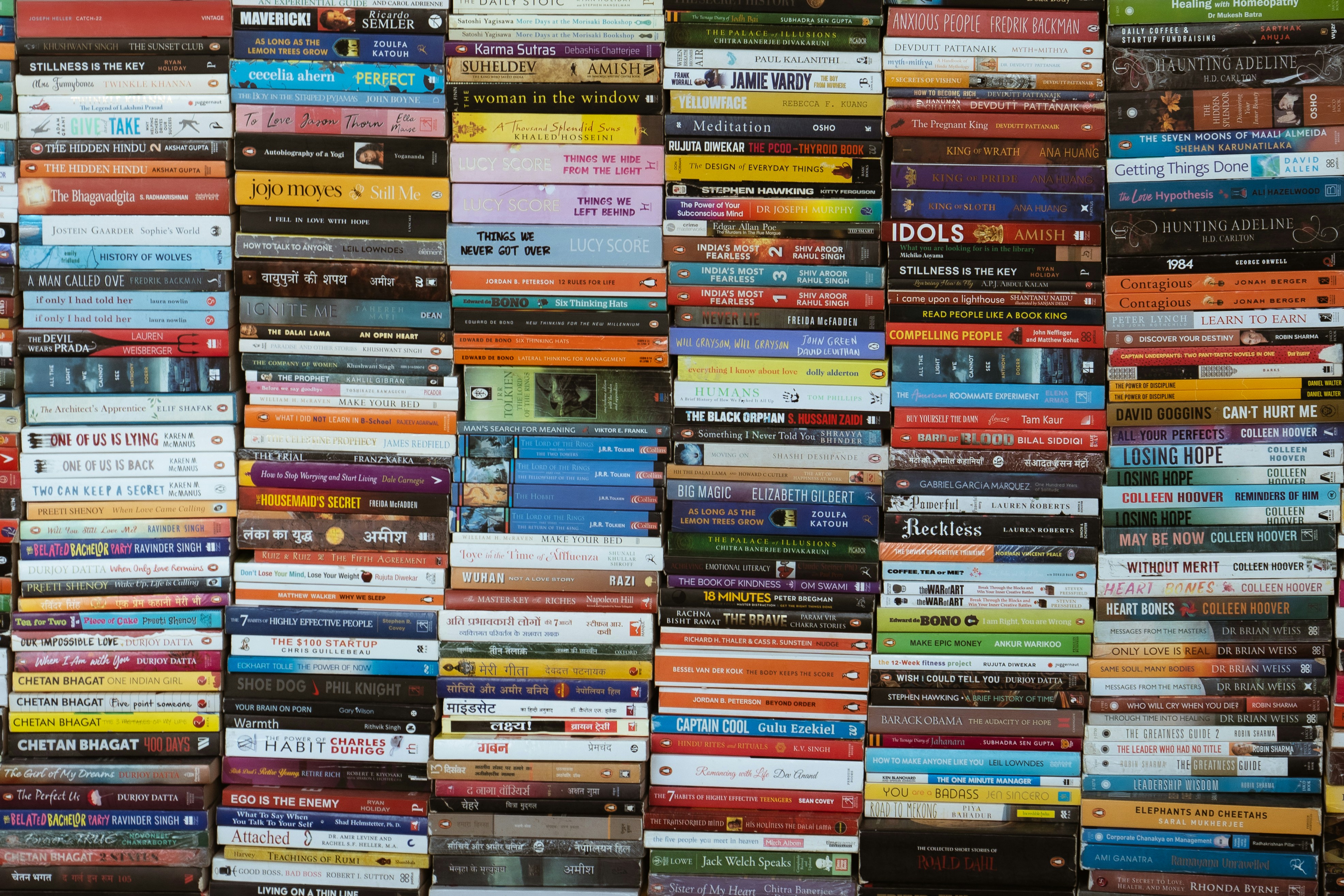 Many colorful books stacked neatly on shelves