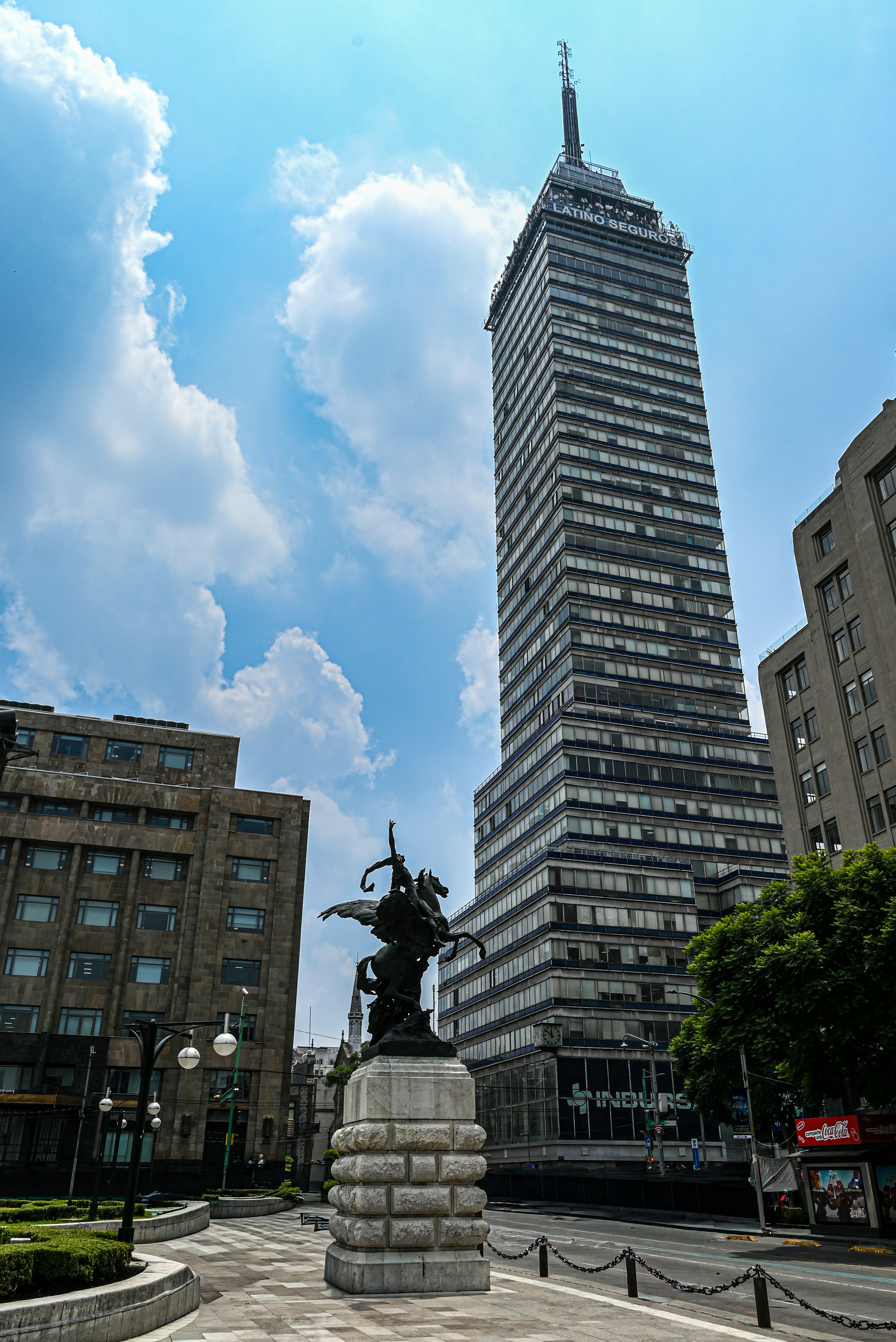 Tall skyscraper with a monument in front