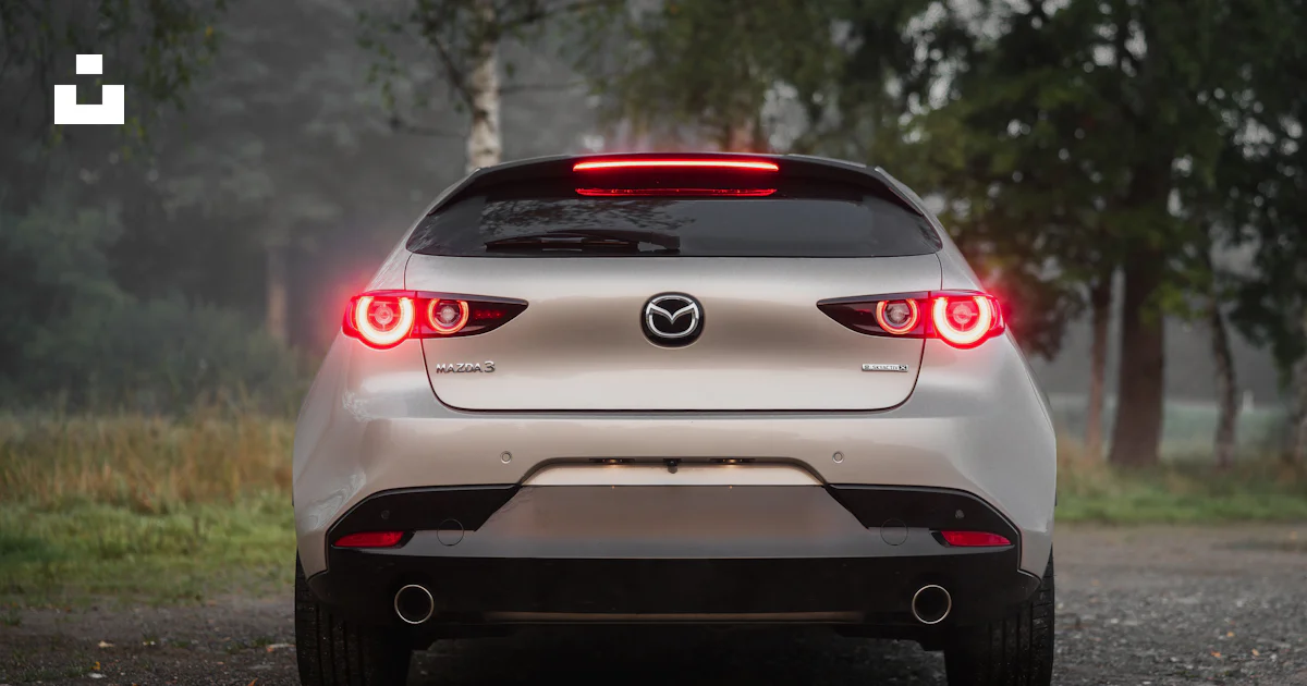 Rear view of a silver hatchback car with taillights illuminated. photo ...