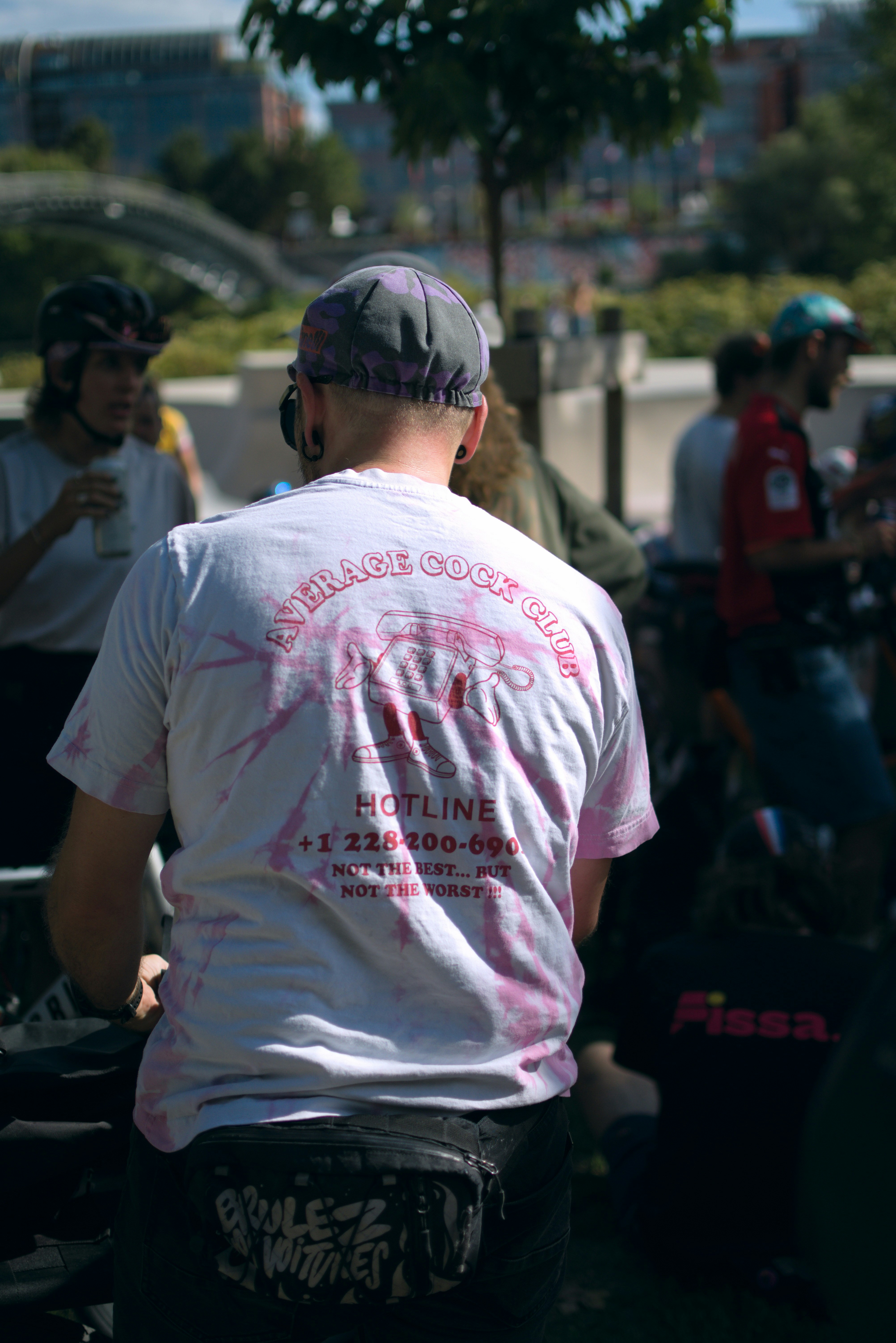 Man wearing a tie-dye shirt with text on back.