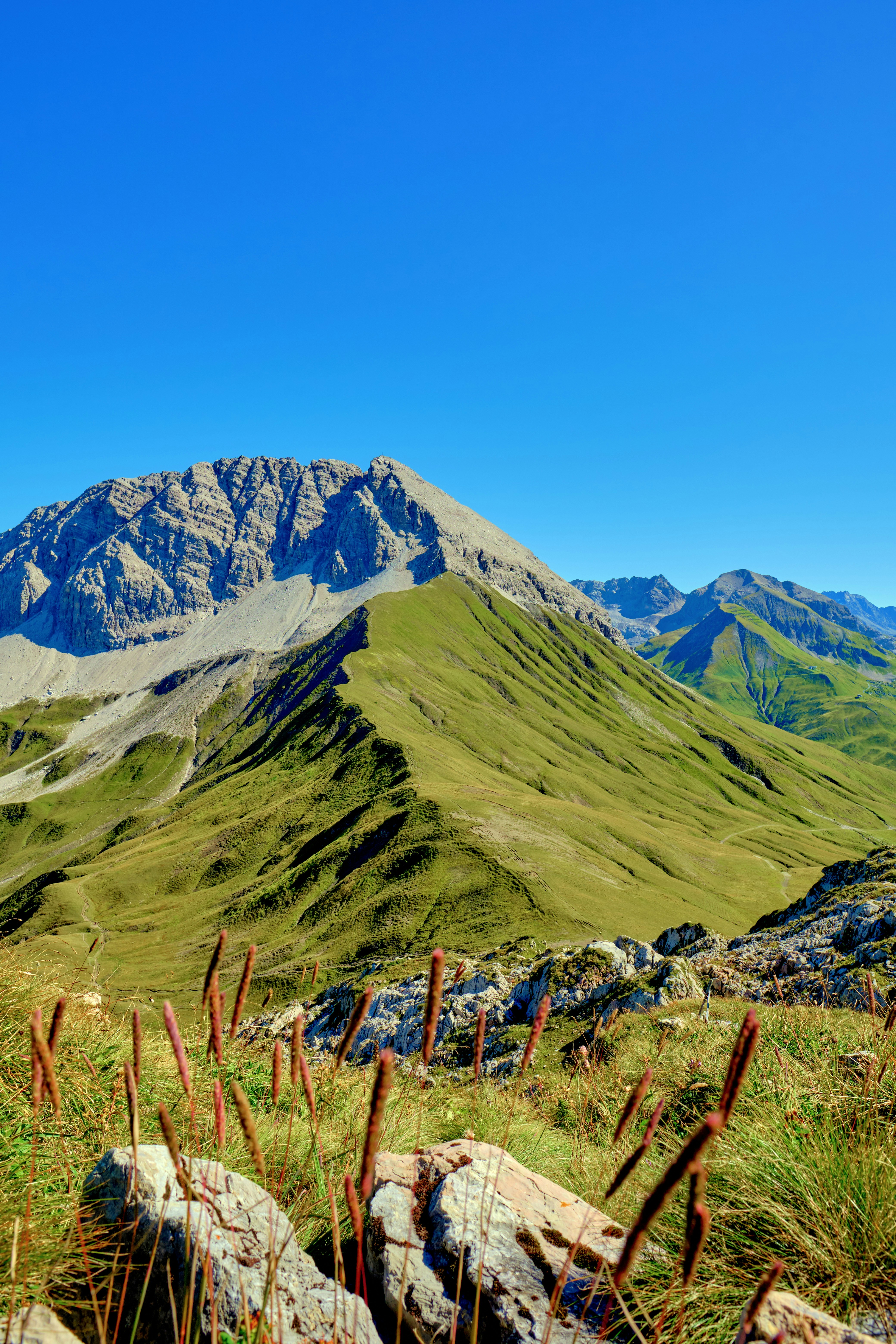 Vast green mountain range under a clear blue sky