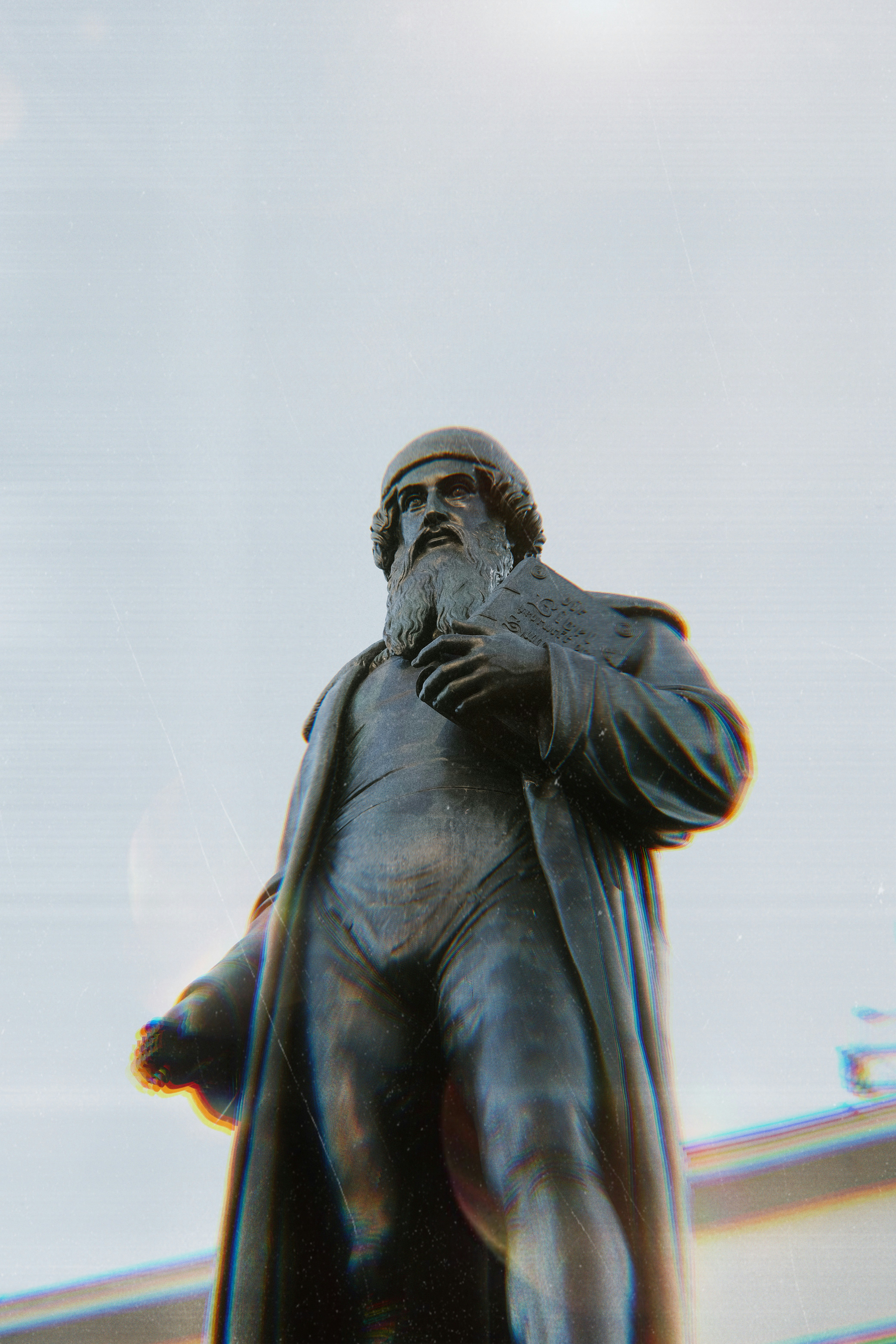 Bronze statue of a man with a beard and hat.