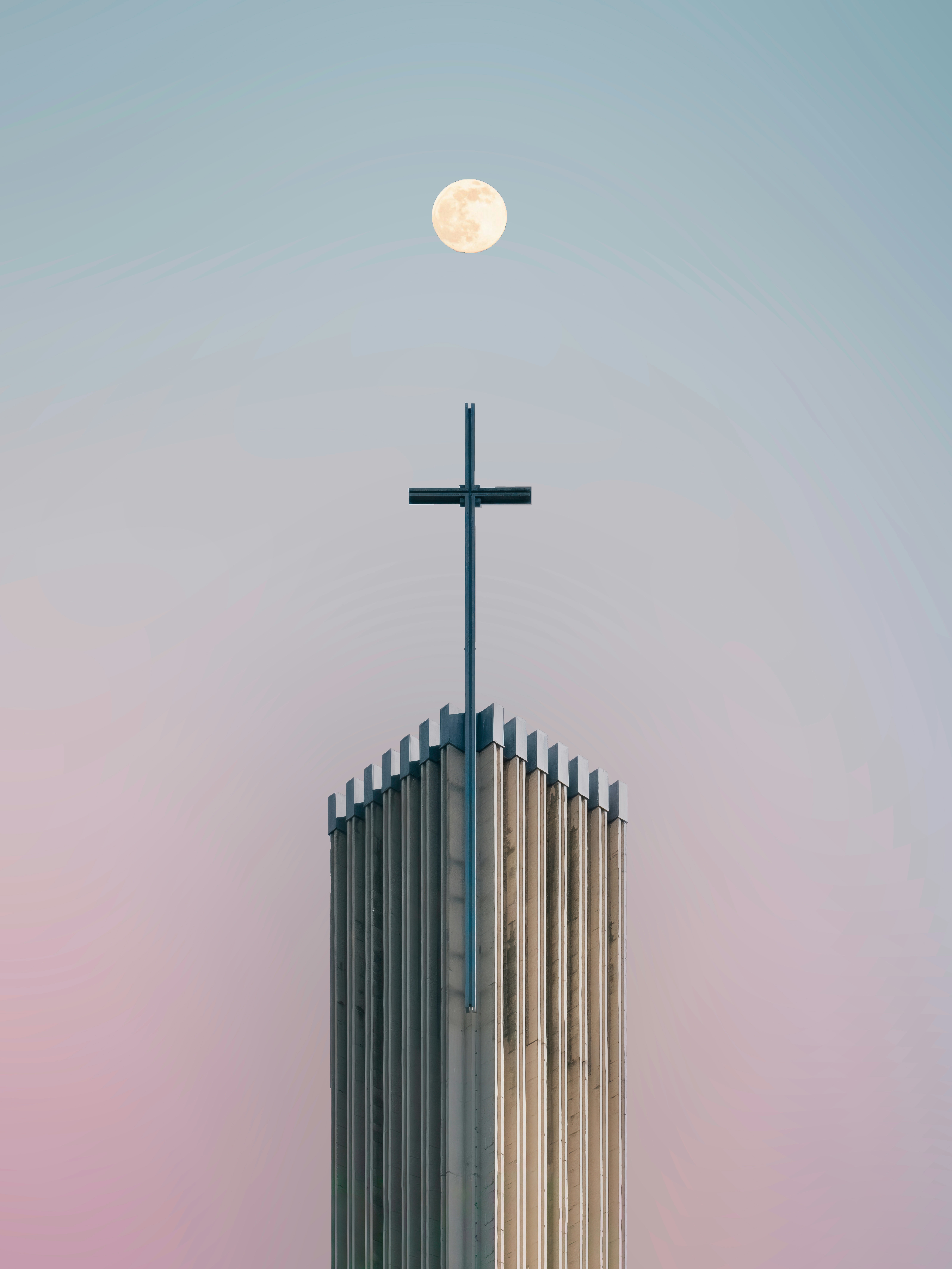 Full moon above church steeple at dusk