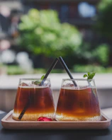 Two iced coffees with mint and straws.