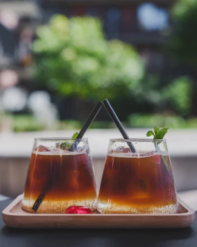 Two iced coffees with mint and straws.