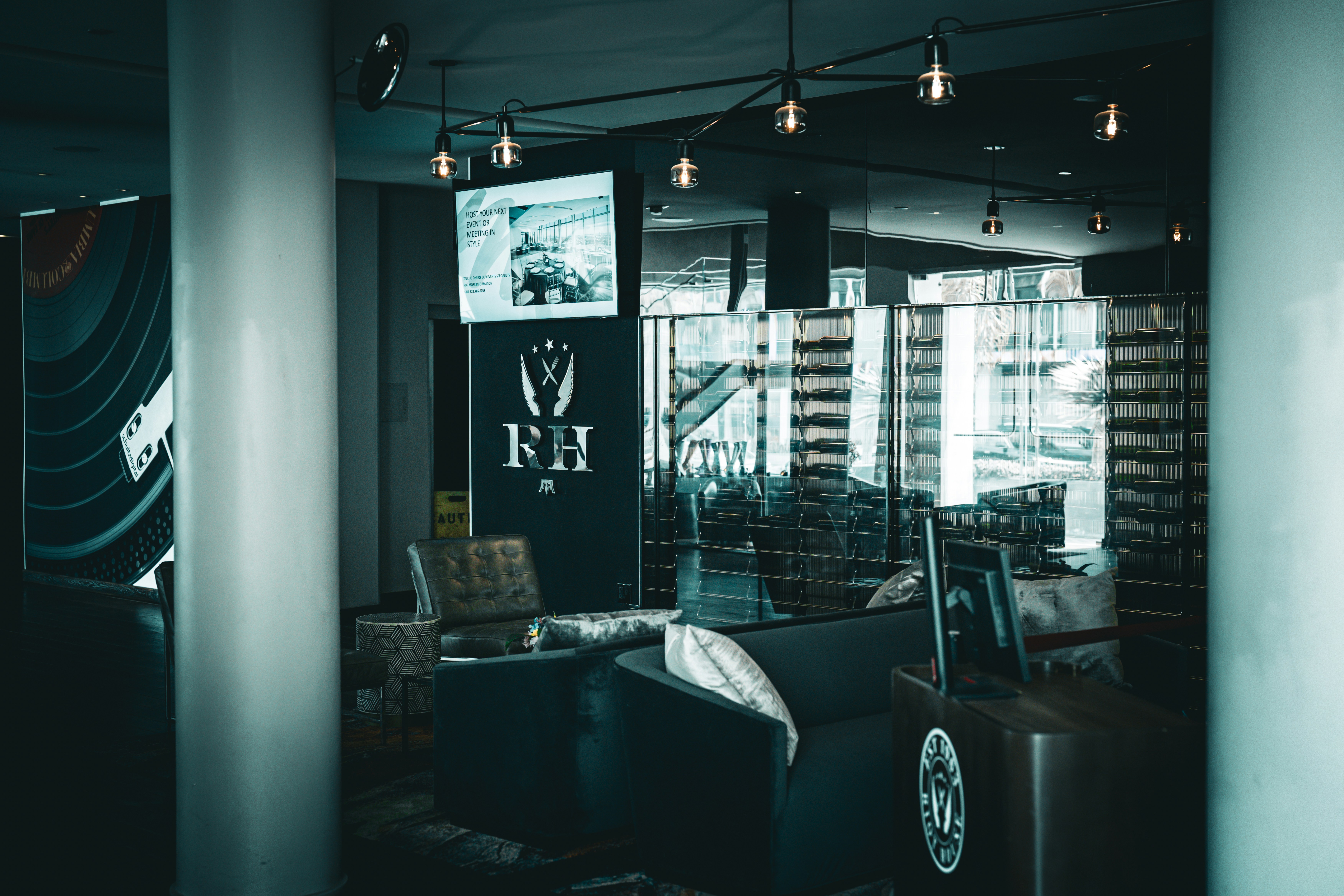 Modern lounge area with dark furniture and ambient lighting