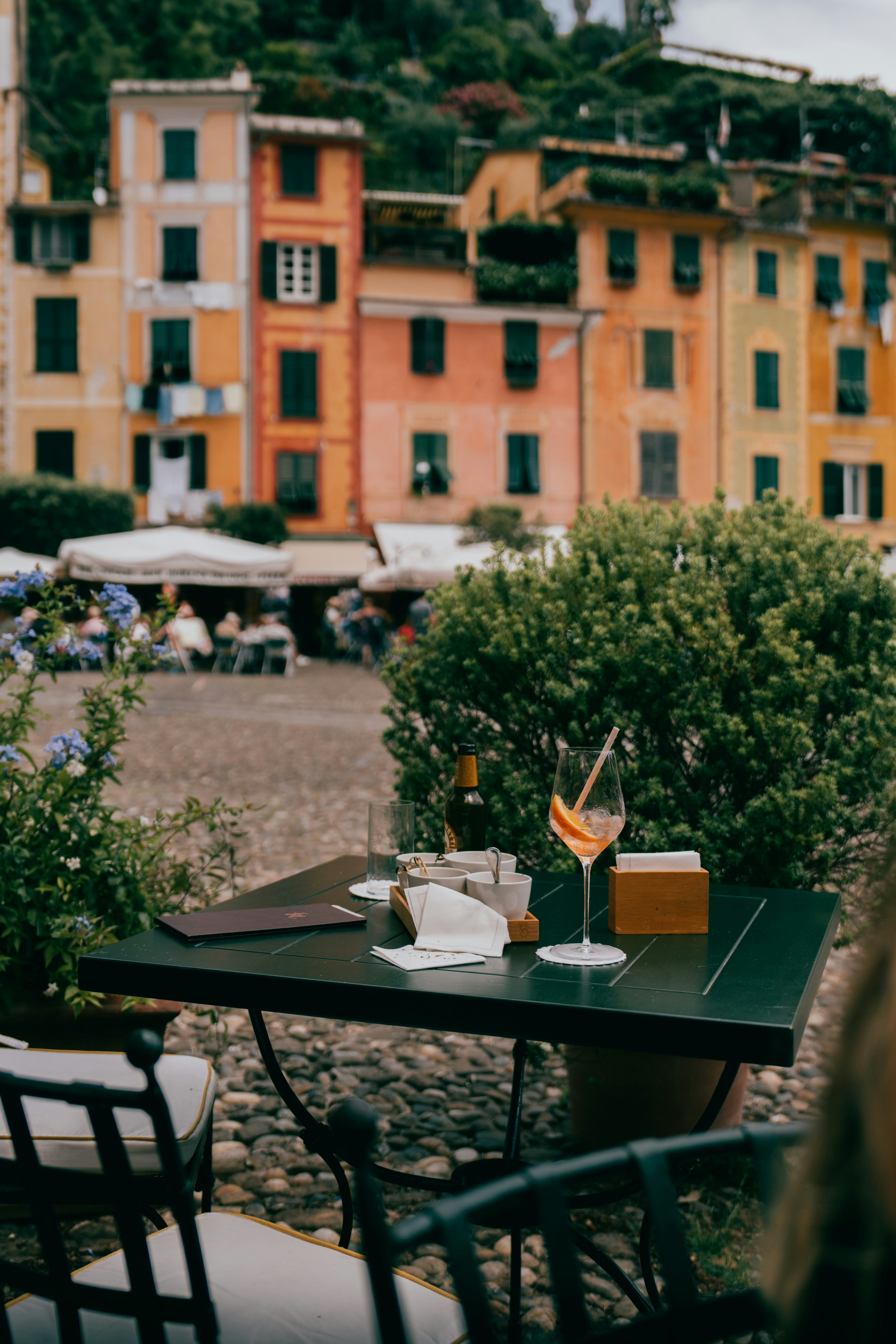 Table with drink overlooks colorful italian buildings