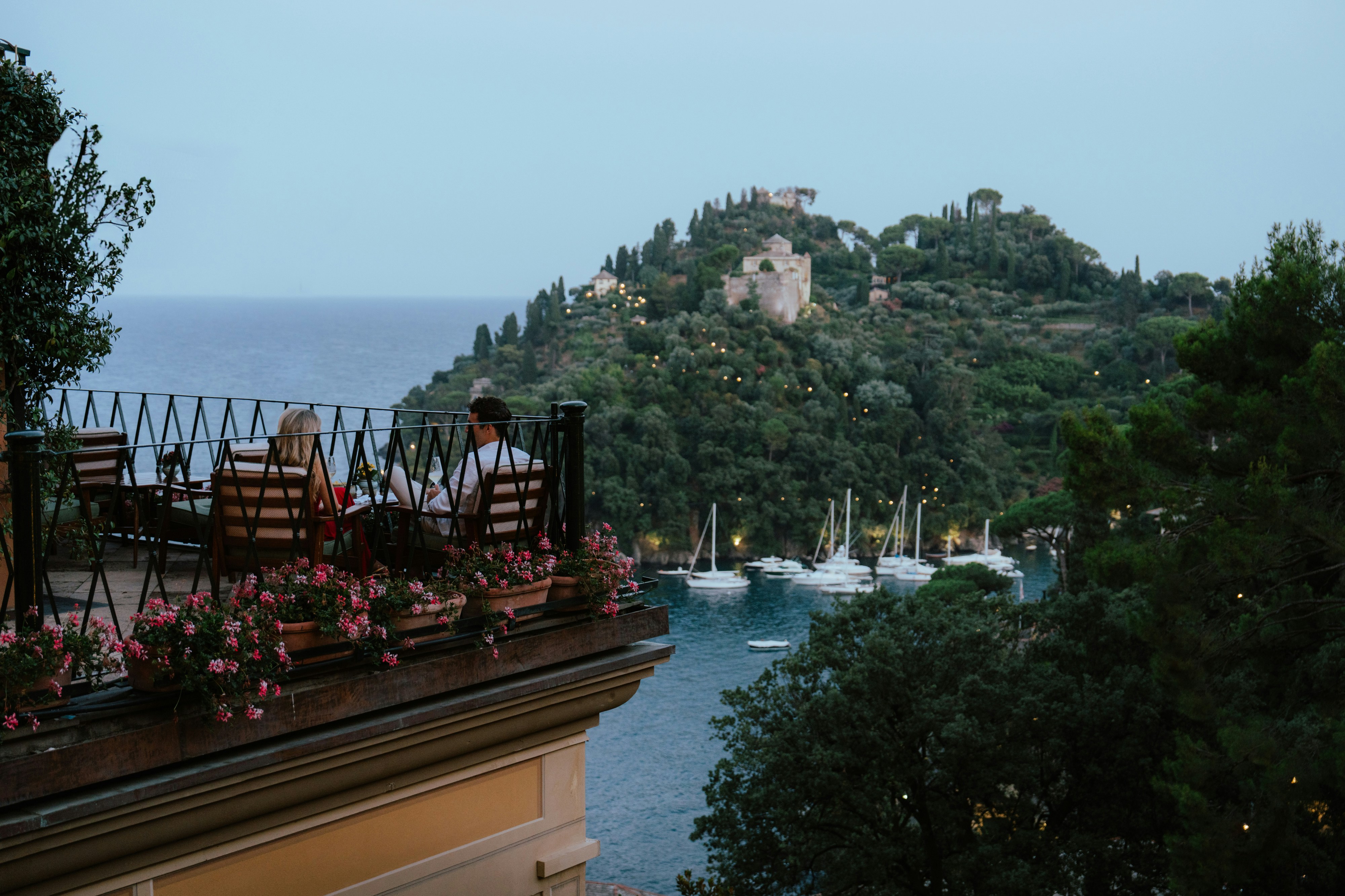 Couple enjoys view from balcony overlooking harbor