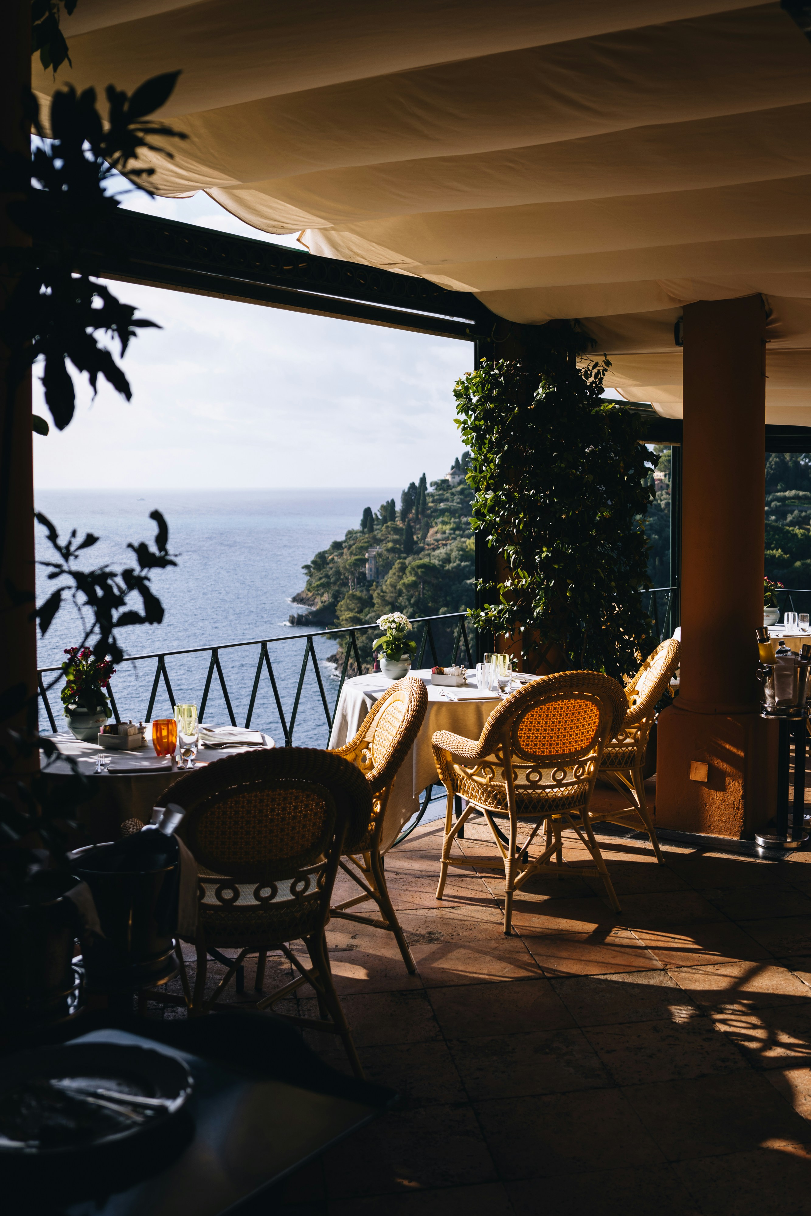 Restaurant terrace overlooking the sea with tables and chairs.