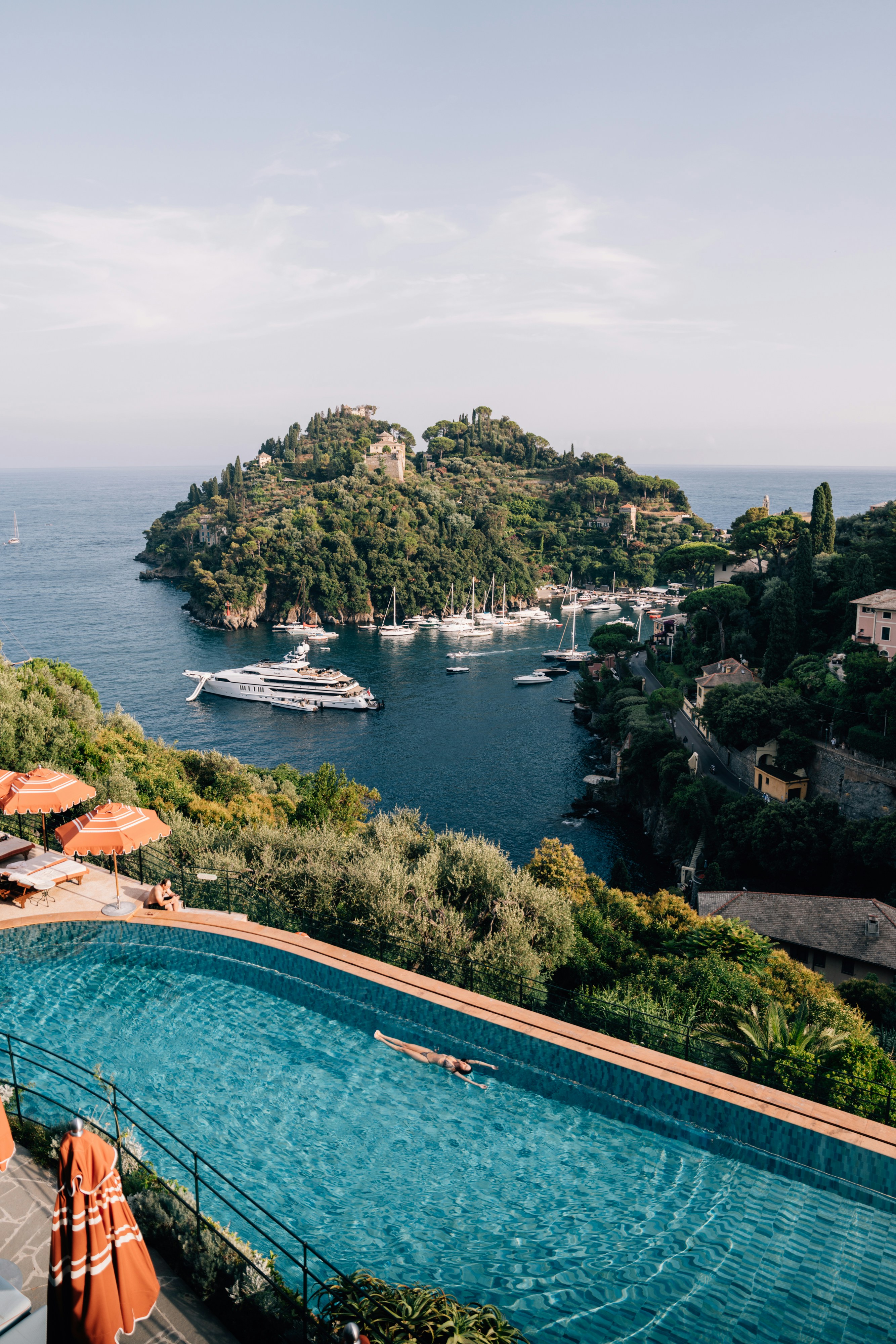 Luxury yacht harbor with swimming pool and coastline.