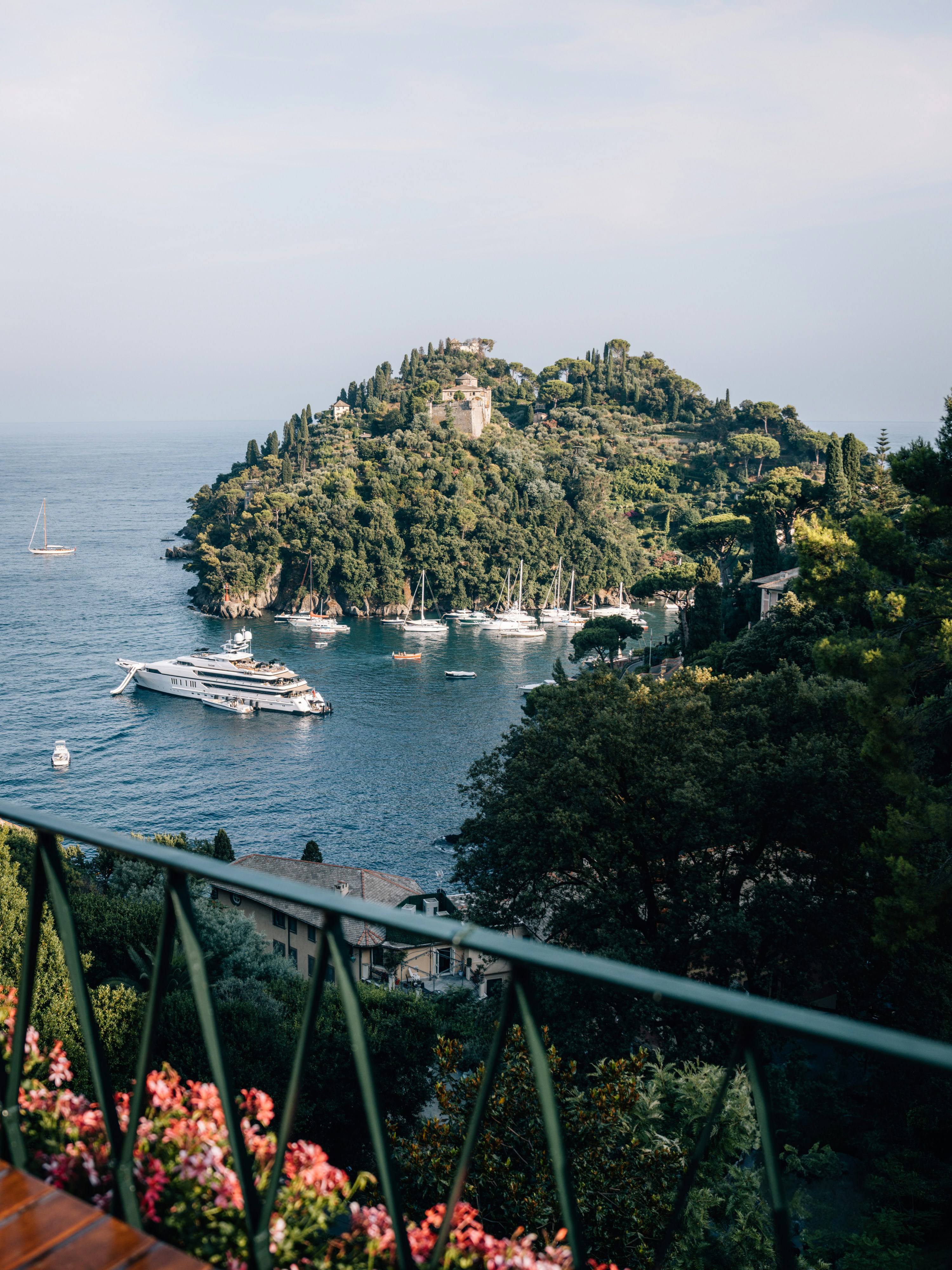 Yachts anchored in a serene bay surrounded by lush green hills.