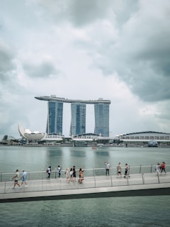 People walk on a pier with marina bay sands in singapore.
