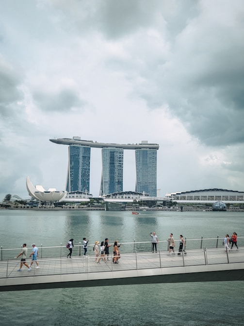 People walk on a pier with marina bay sands in singapore.
