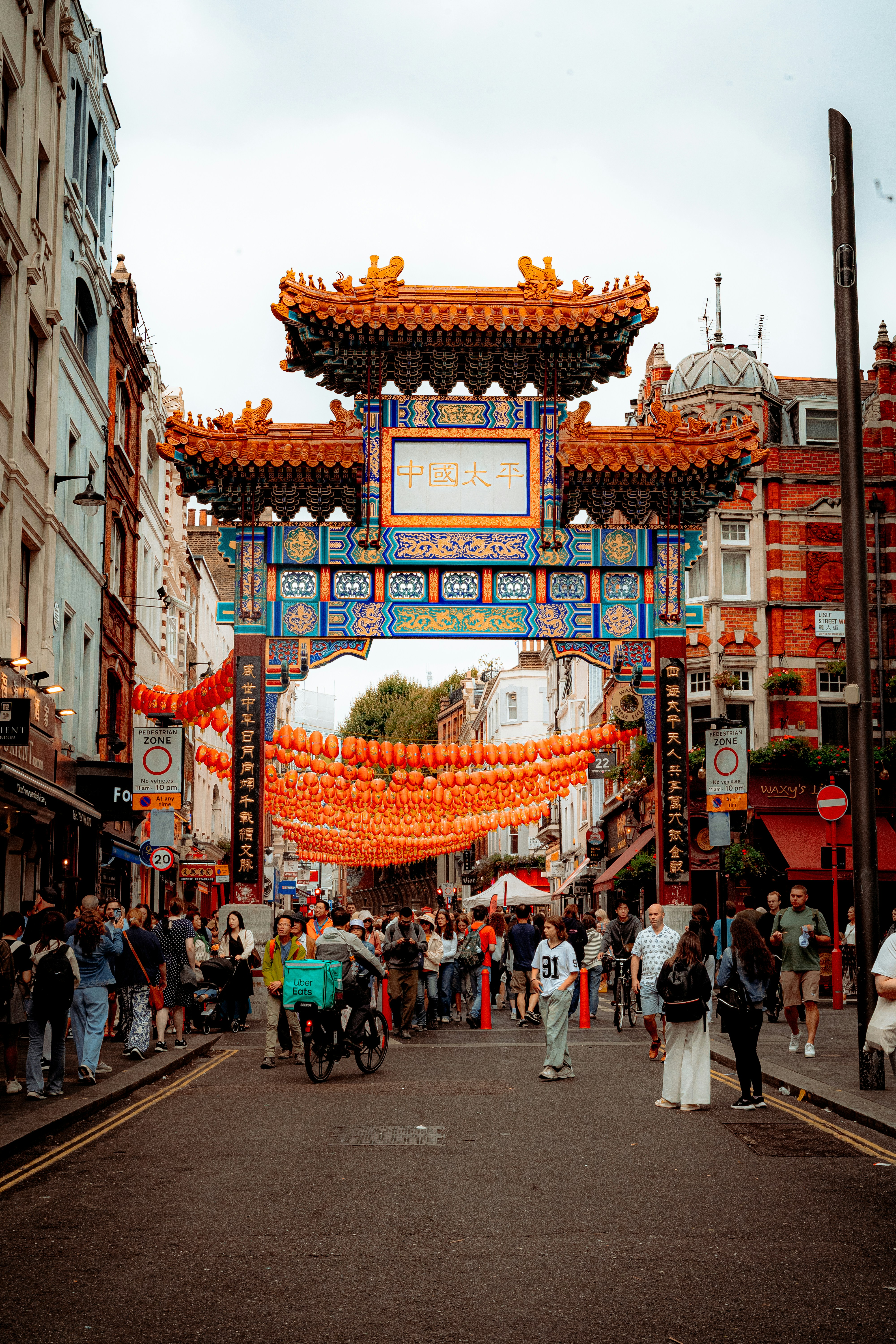 Crowded street with ornate chinese arch and lanterns