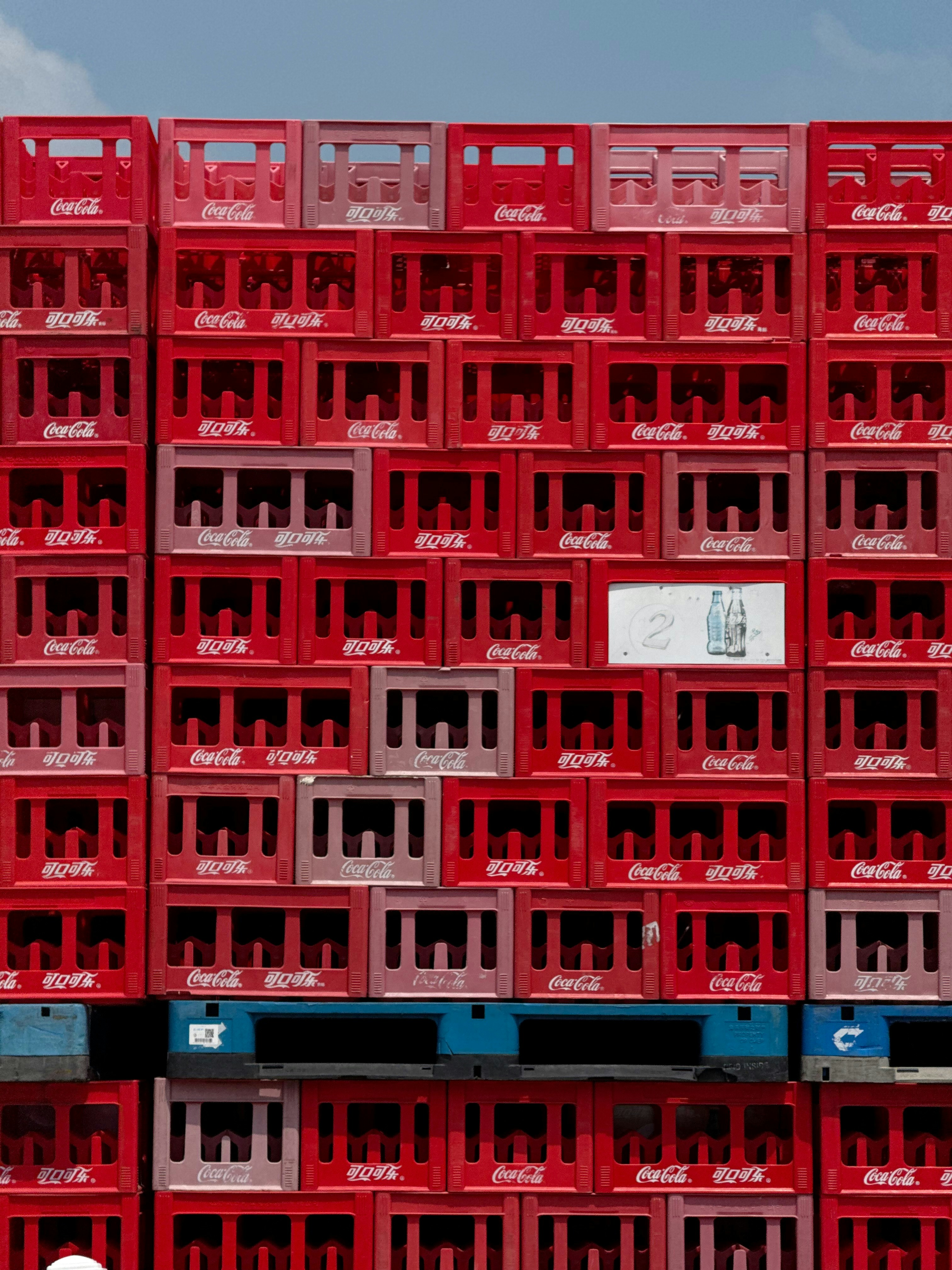 Stack of red coca-cola crates with bottles inside bottles